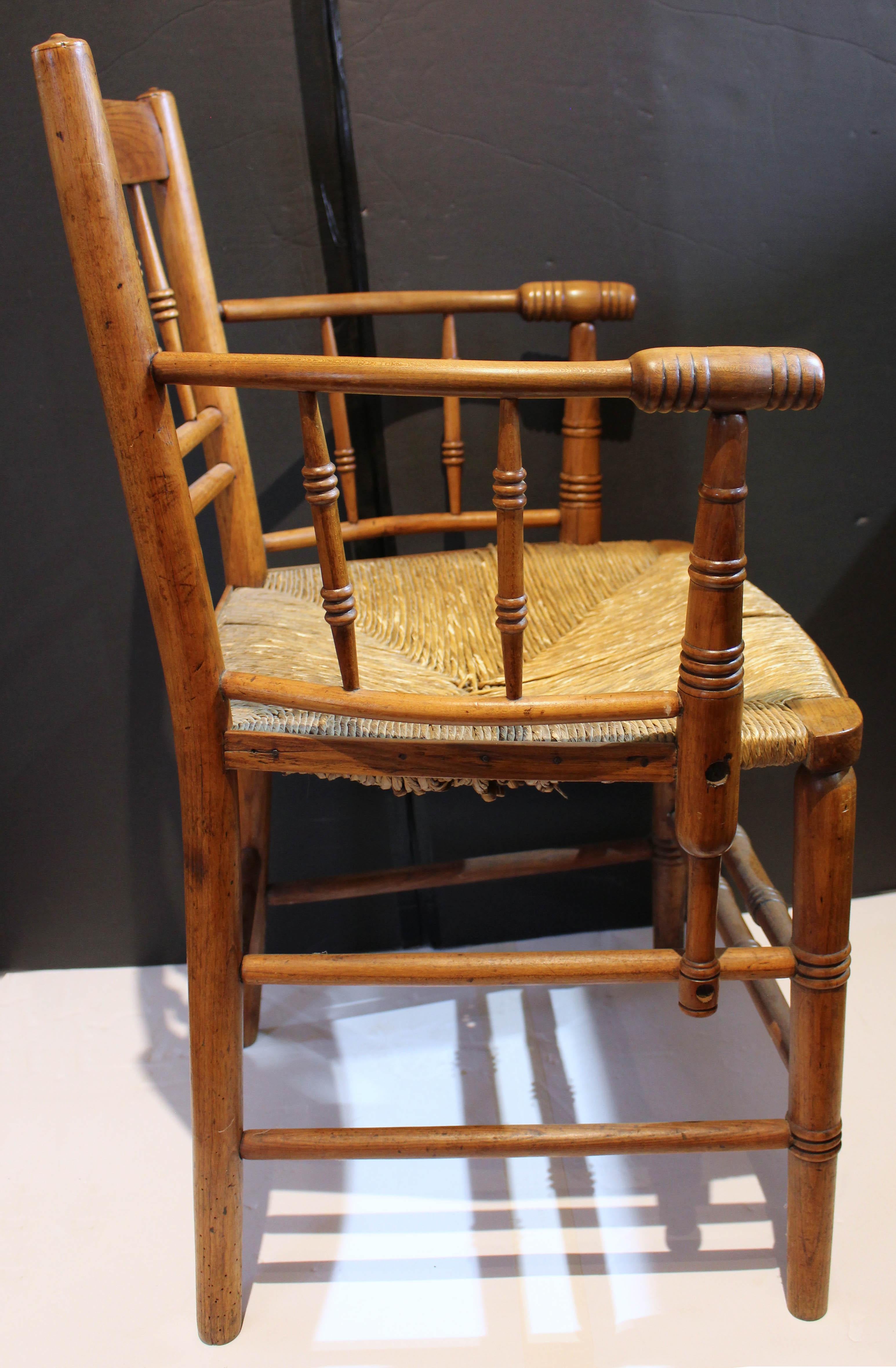 Early 19th century fruitwood arm chair, English. Charming with ring turned spindles, arm supports & stretchers. Rush seat. Minor rush losses.
21.5