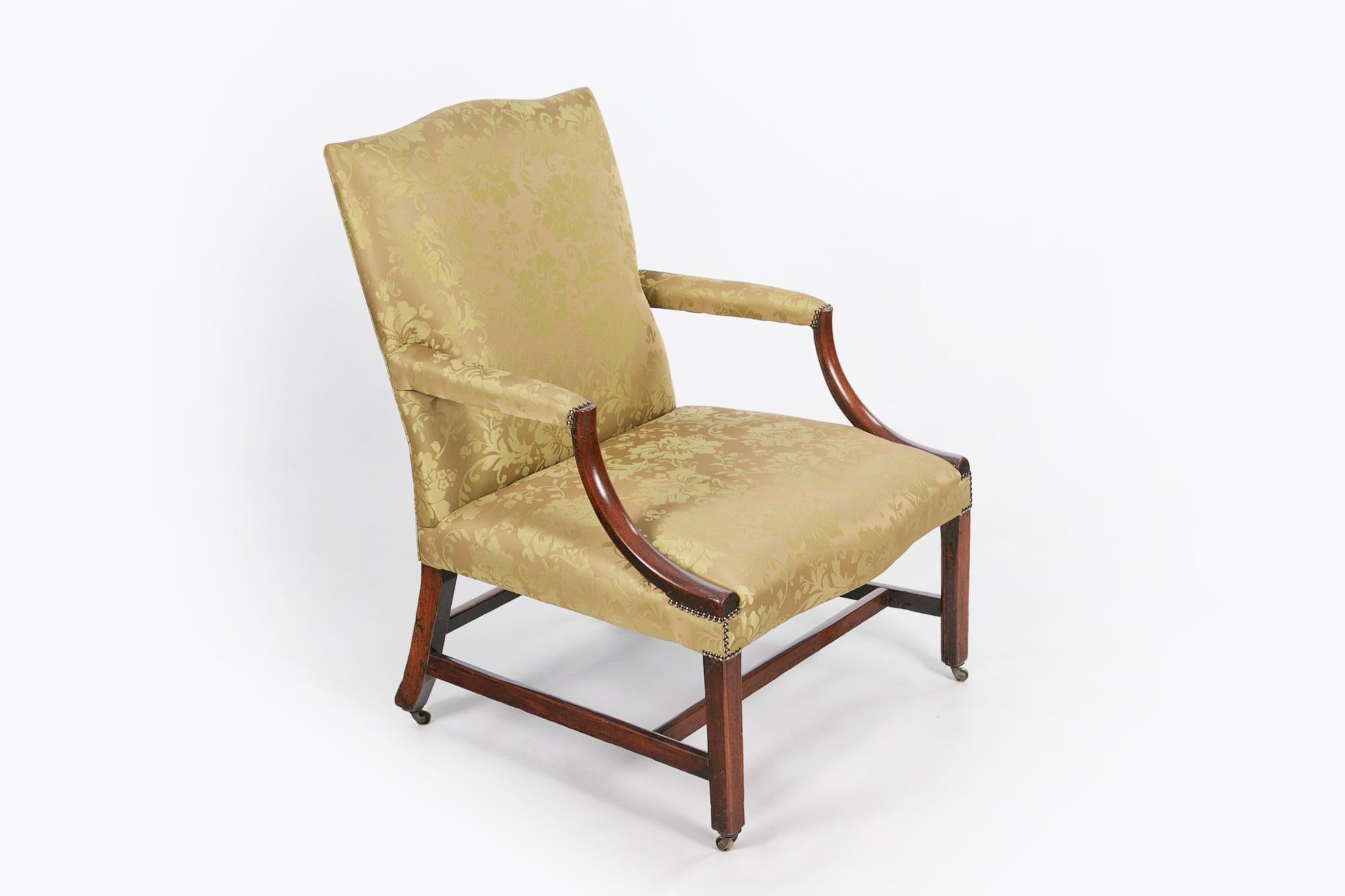 Early 19th century Gainsborough mahogany armchair in the manner of Chippendale, upholstered in sage green silk damask in the traditional 19th century style with brass studding, the shaped padded back above padded arms with down swept arm supports