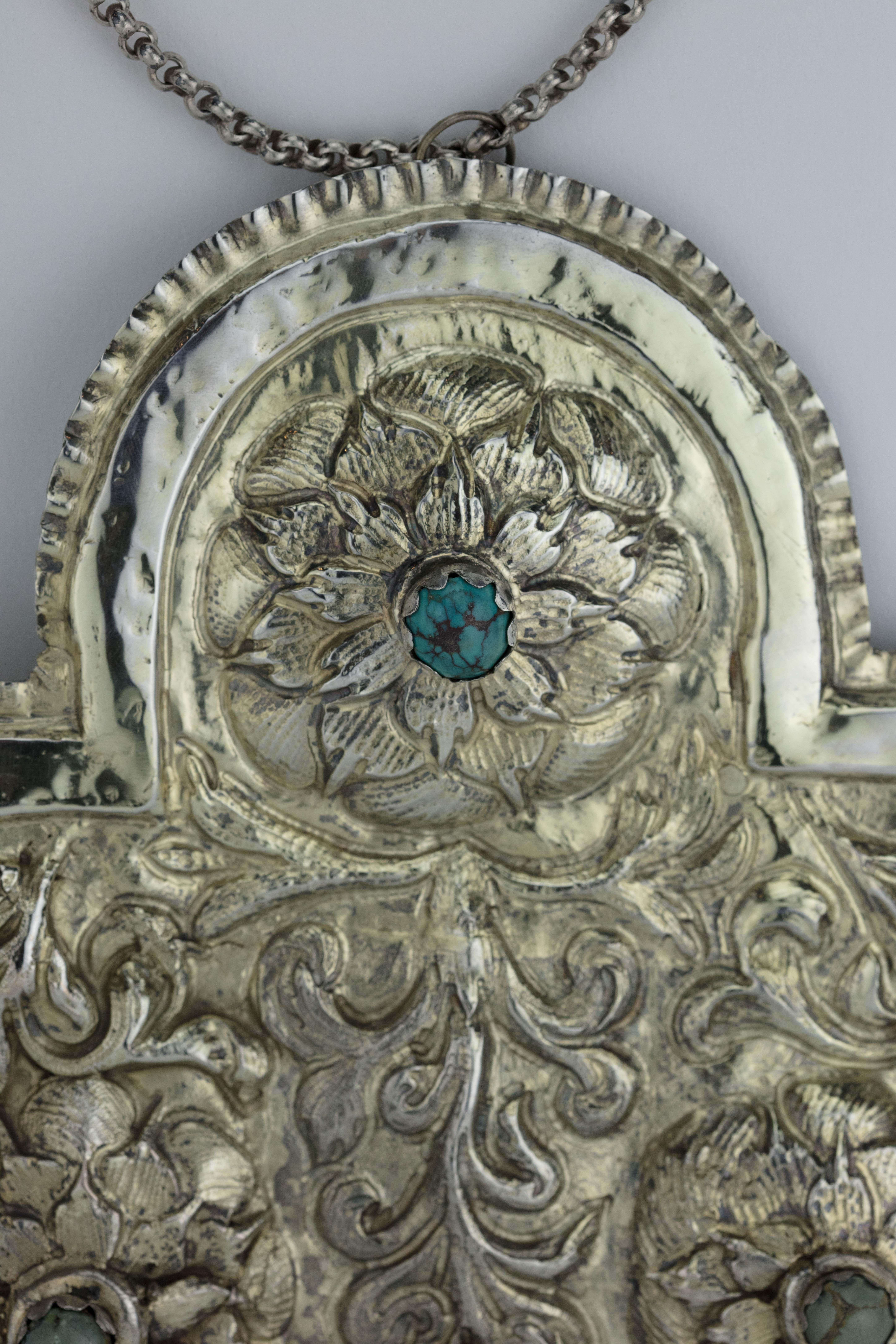 Handmade silver Torah shield (Tas), Galicia, circa 1800.
Arched rectangular, embossed in high relief with four flowers with scrolling stems, each set with a cabochon turquoise, fitted with compartment for portion plaques waved rim, comes with the