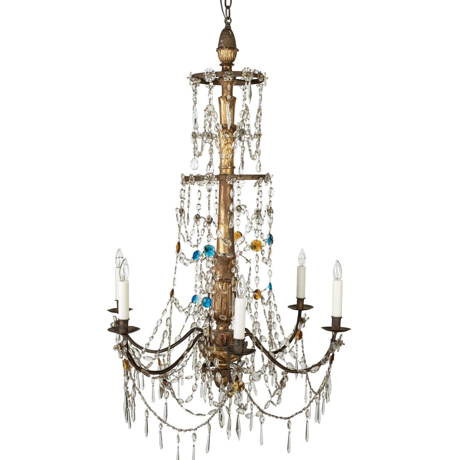Early 19th century Genoese chandelier consisting of a carved giltwood body, original eight iron arms and three tiers of original crystal prisms (clear and colored). This chandelier includes extra chain, a matching canopy and is newly-wired for use