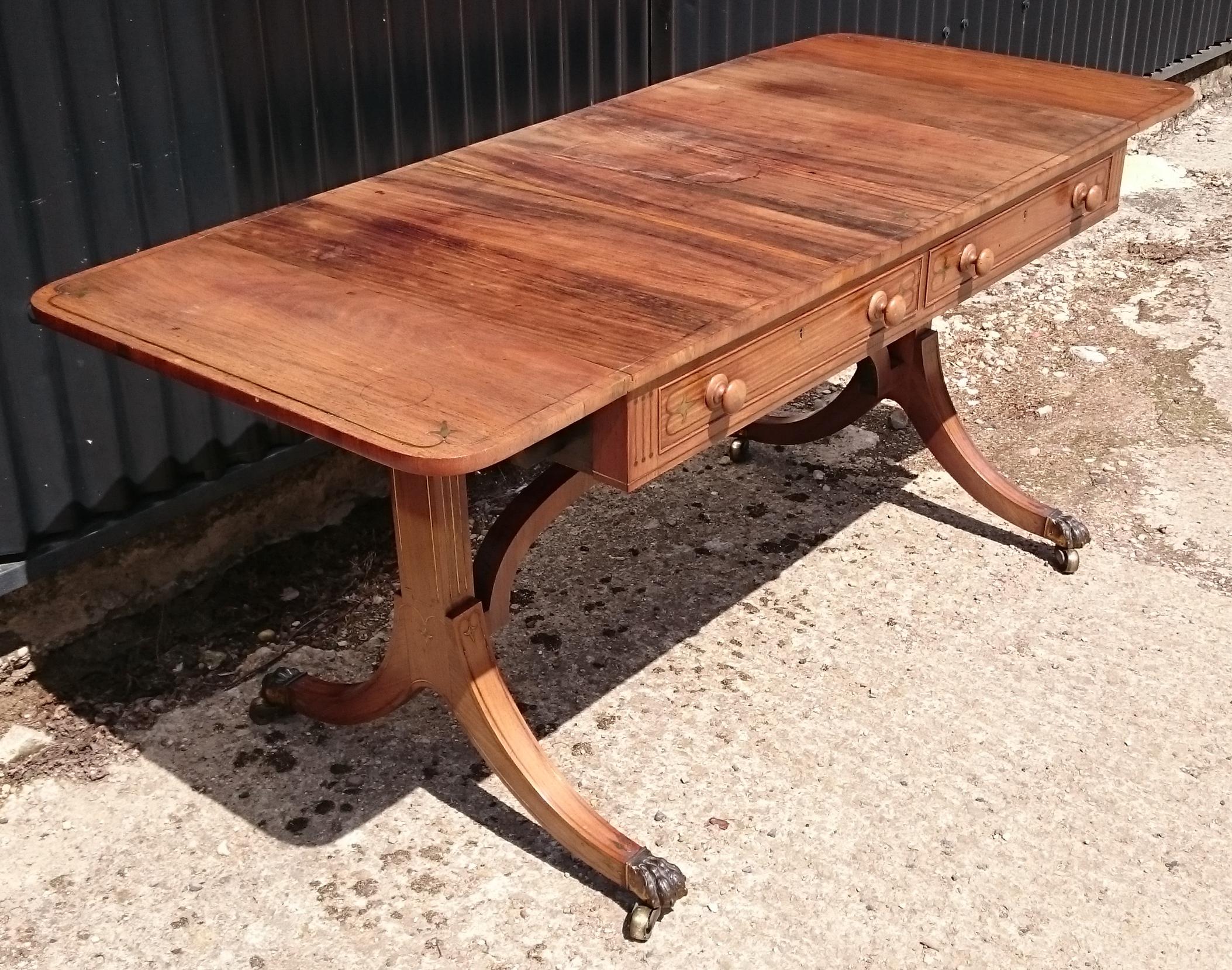 Early 19th century George III period antique sofa table. This sofa table really has it all, it is narrow front to back, it has a high stretcher, the stretcher is curved, it has faded to a wonderful honey color, it has brass stringing, it has cedar