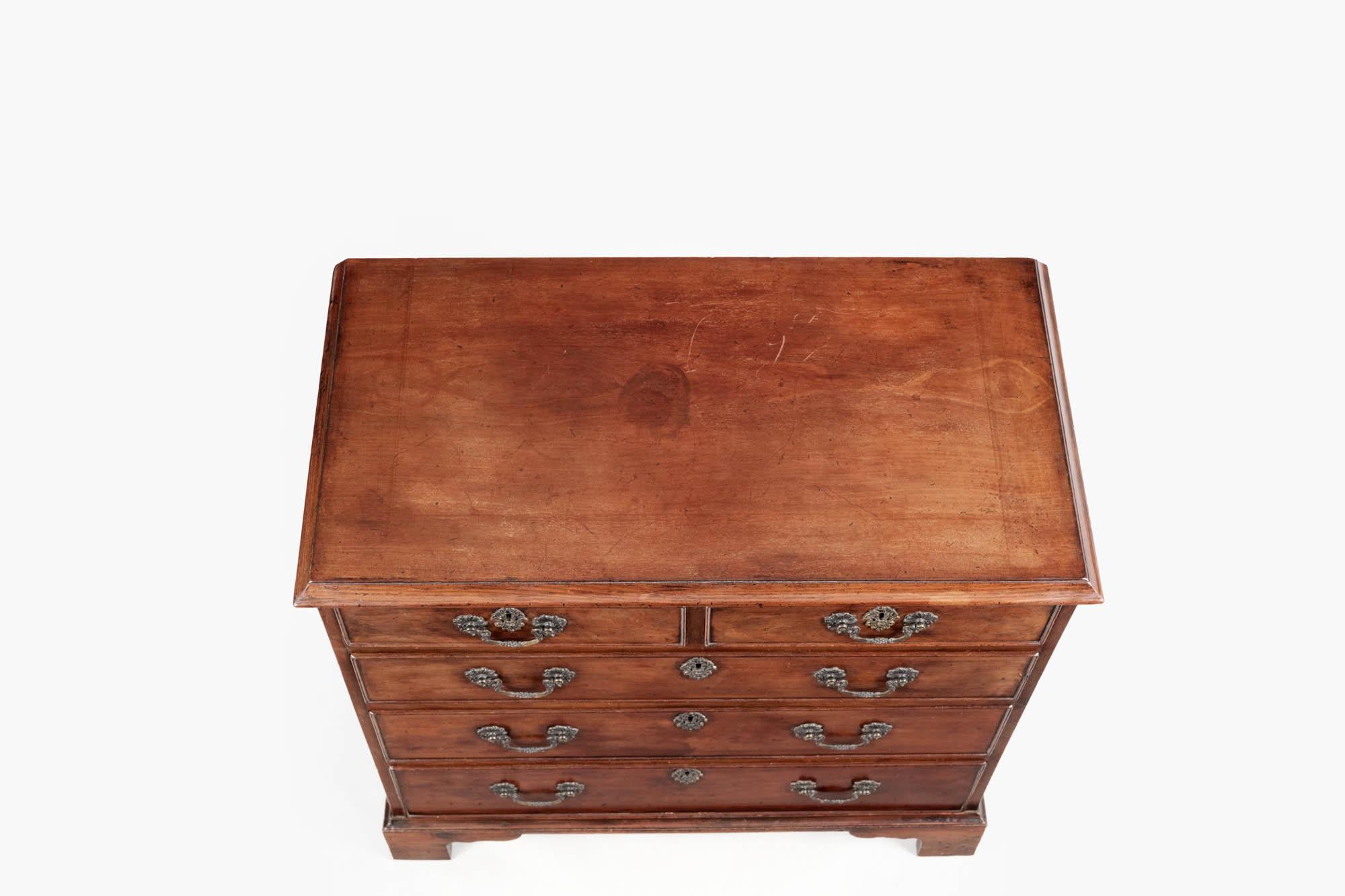 Early 19th century George III bachelor chest, the moulded top raised above two short and three long cockbeaded drawers with brass pulls and escutcheons terminating on ogee bracket feet.