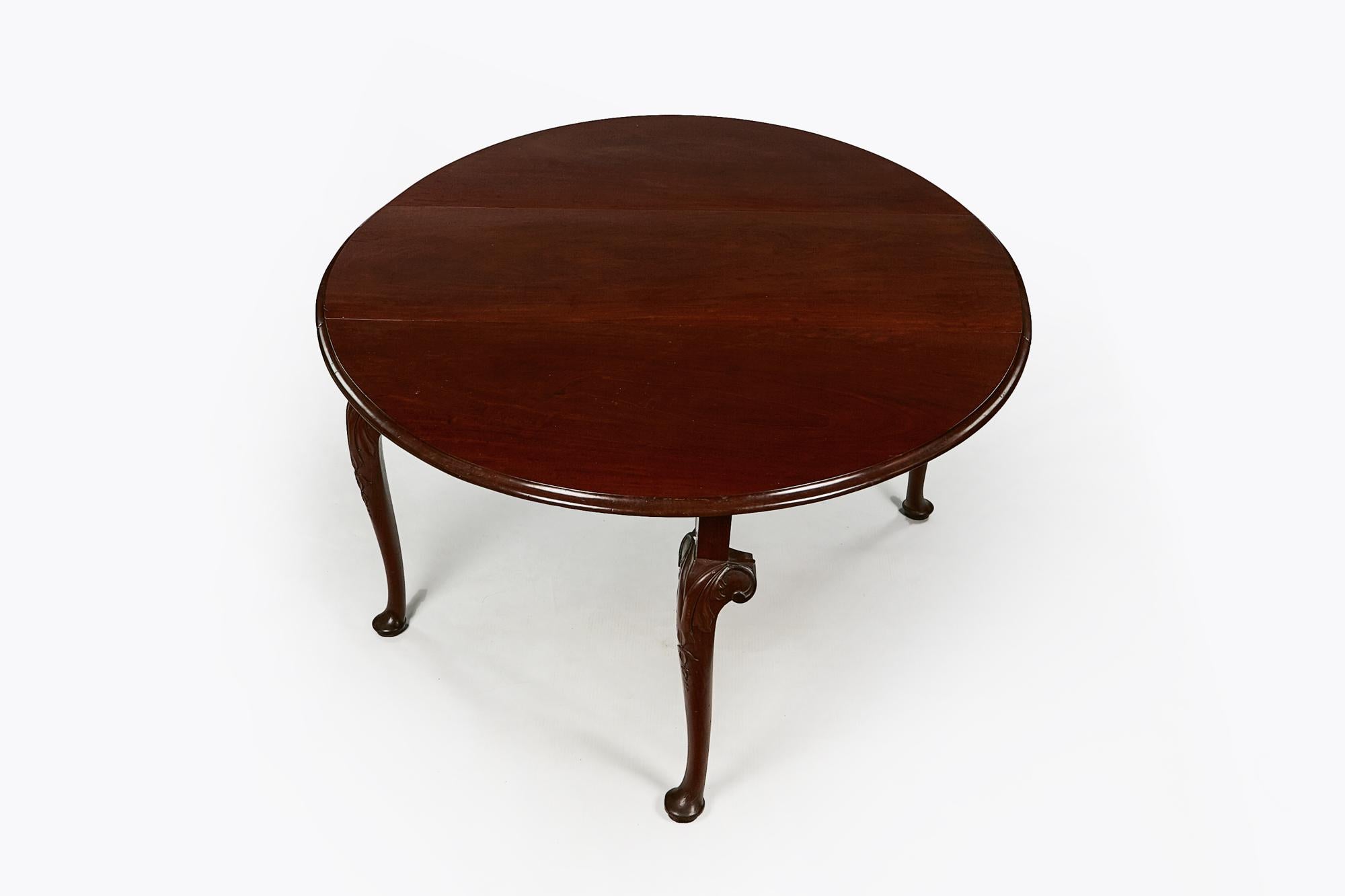 Early 19th century George III flame mahogany oval gate leg drop-leaf table. The molded top above shaped end rail supported on cabriole leg with carved acanthus and trailing bell husk motif detail terminating on pad foot.