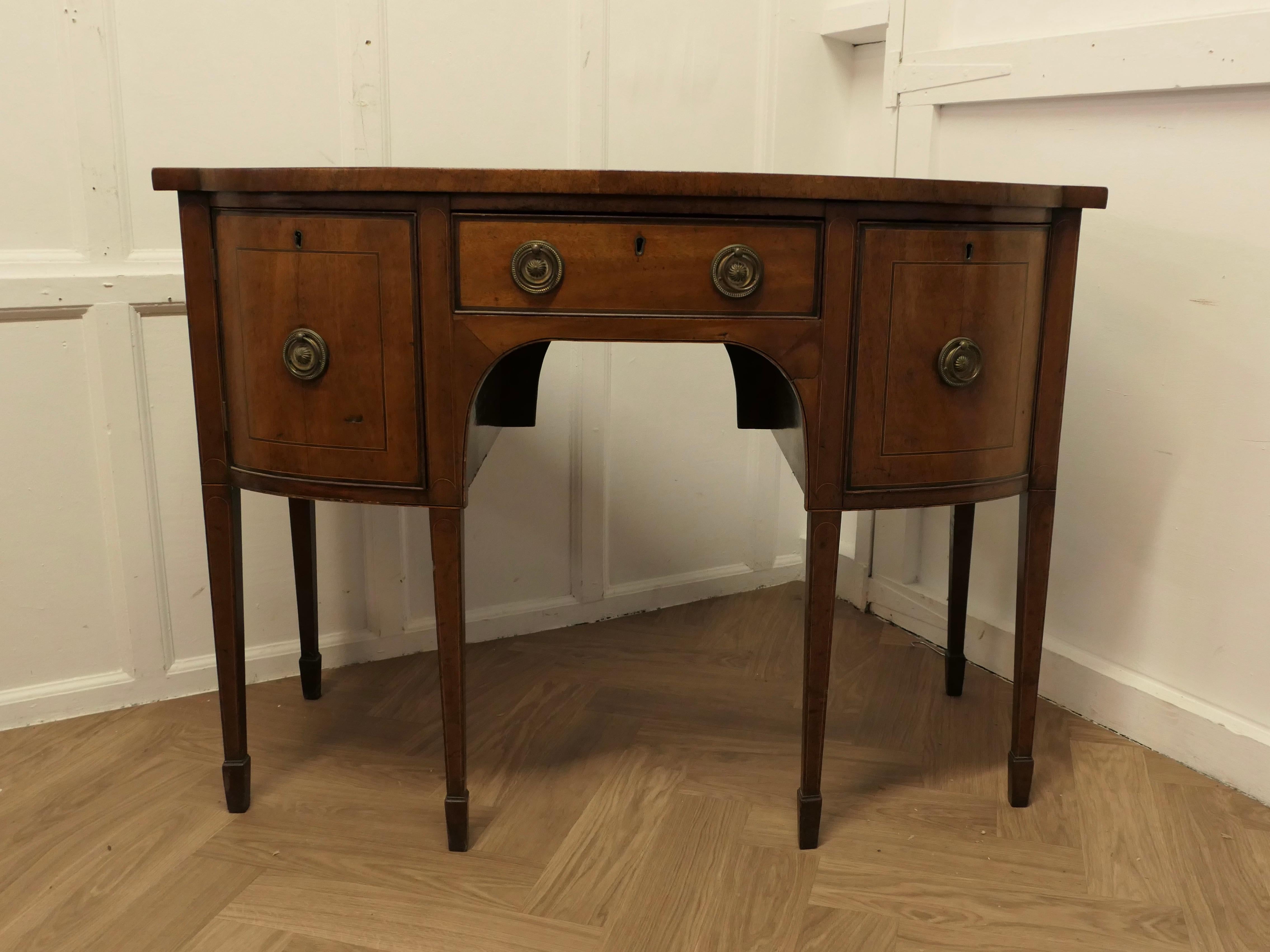 Comò in legno di noce con fronte ad arco dei primi del XIX secolo 

Si tratta di un delizioso pezzo antico, con manici ad anello e un'affascinante conchiglia di grandi dimensioni nella parte superiore. 
La credenza ha gambe leggermente affusolate,