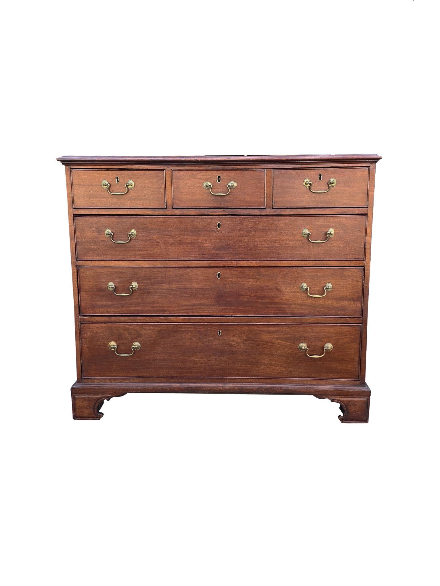 Classic and elegant, this George III chest of drawers was handcrafted circa 1800. It is made from walnut, recently refinished with a warm red-brown tone. The bail pulls are brass. We love the simplicity of this design. It's one of balance and