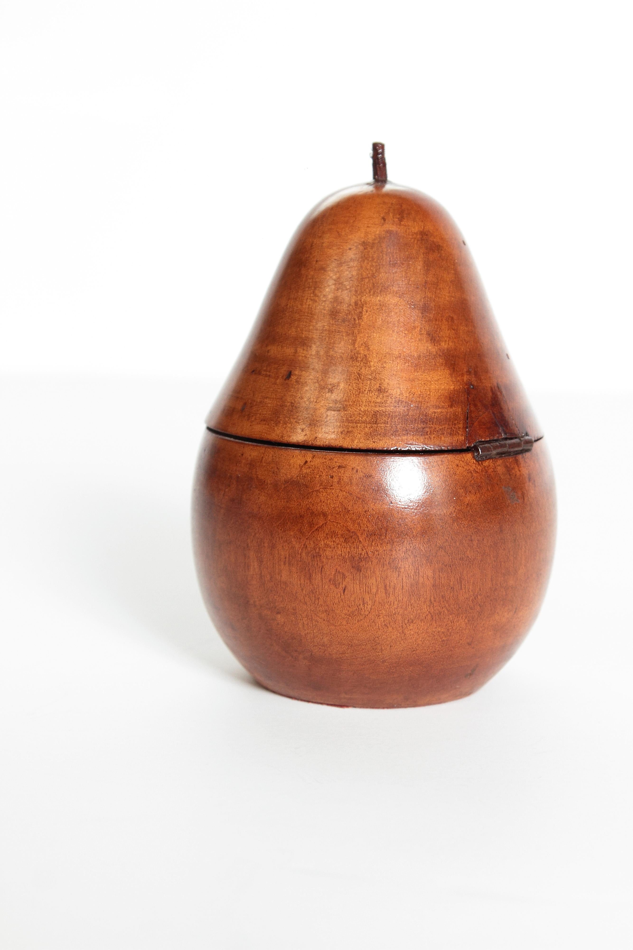A beautifully shaped pear form tea caddy with a rich warm finish and patination. Intact stem of wood on hinged lid. The base has an oval brass escutcheon.