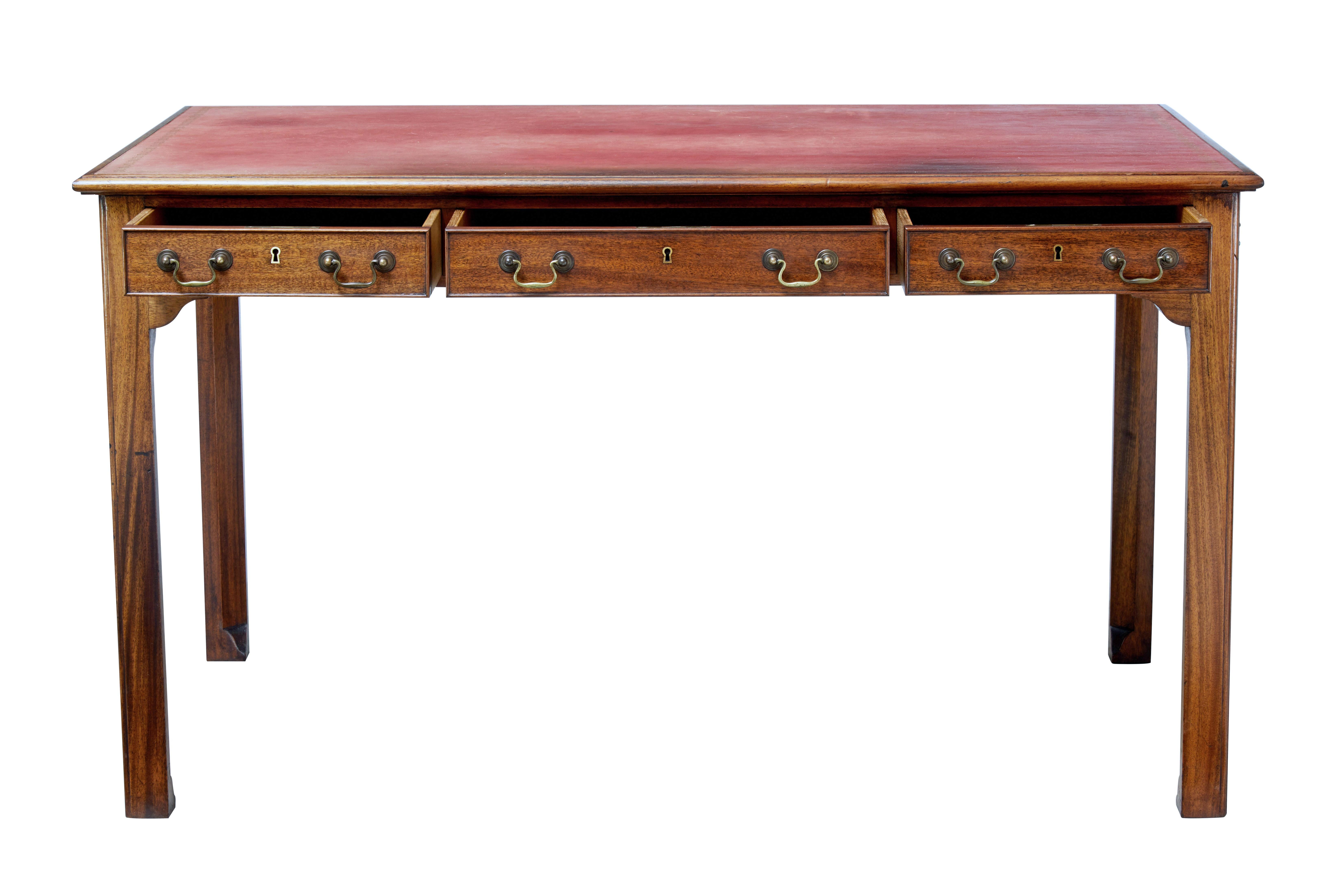 Late George III English writing table with leather top, circa 1810.

Desk front with 3 drawers below the writing surface and original brass swan neck handles. Dummy to reverse with further handles to the sides.

Possibly the original red leather