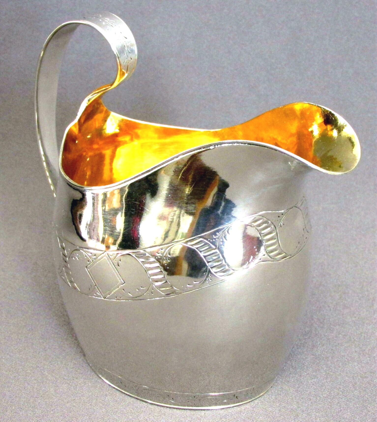 A very handsome and heavy sterling silver cream jug of oval bellied form, decorated with an engraved band of repeating 'bright cut' guilloche motifs and a loop shaped handle with bright-cut detail, the interior exhibiting an exceptionally fine and