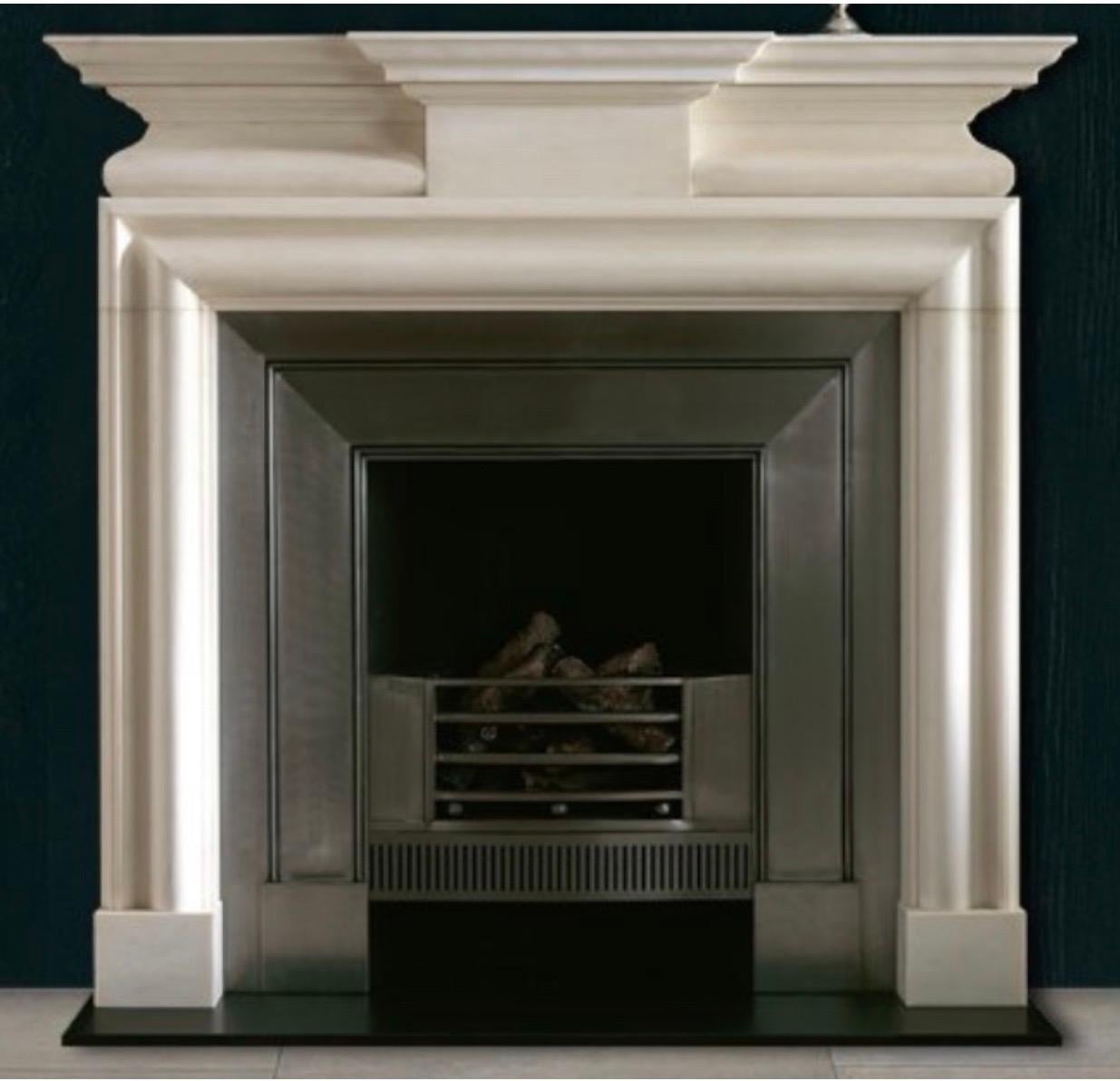 A large early 19th century Georgian style monumental statuary marble fireplace surround. A breakfront corniced shelf rests above an unadorned projecting central tablet flanked by a semi barrel moulded frieze, all resting on a well carved bolection