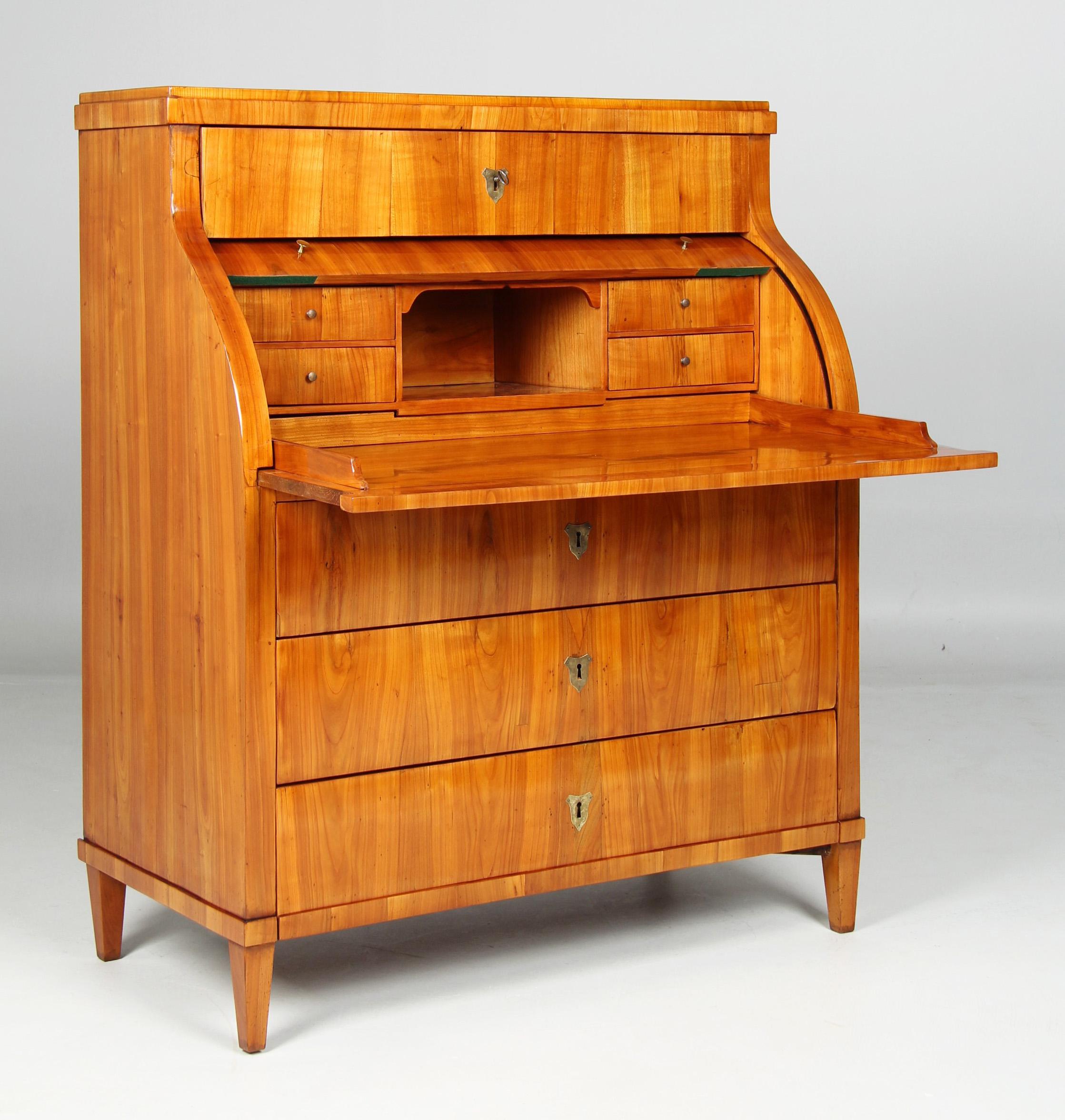 Antiguo buró cilíndrico de la época Biedermeier del sur de Alemania, hacia 1820

Dimensiones: Alto x Ancho x Fondo: 125 x 101 x 55 cm

Descripción:
Mueble de pie sobre patas puntiagudas con tres cajones, la tapa cilíndrica y otro cajón