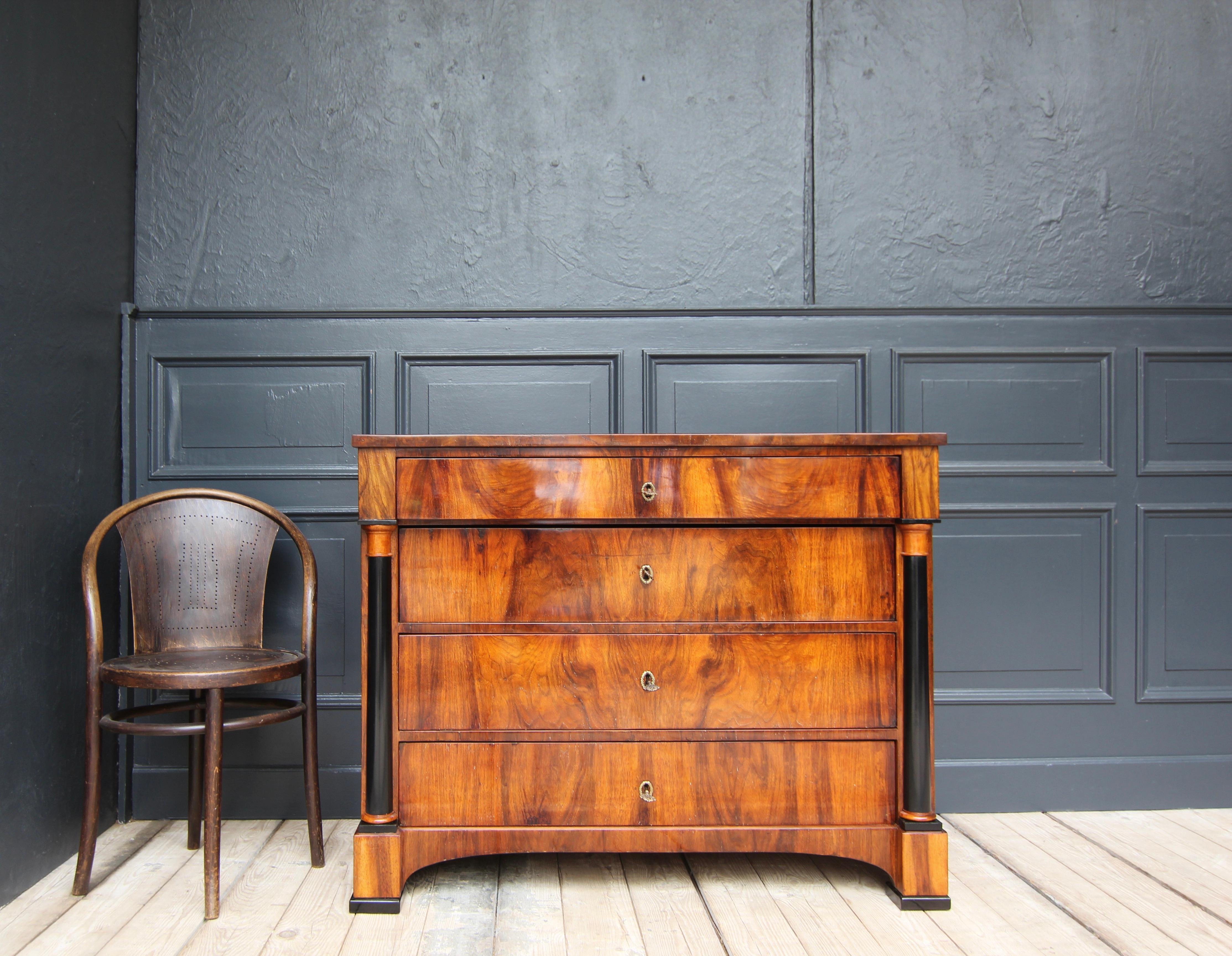 A Biedermeier column chest of drawers, Southern German circa 1820. Walnut veneer on pine. 

On 4 block feet with ebonised foot plates, a four-drawer corpus with slightly projecting top plate. The 3 drawers are flanked by ebonised Tuscan half-columns