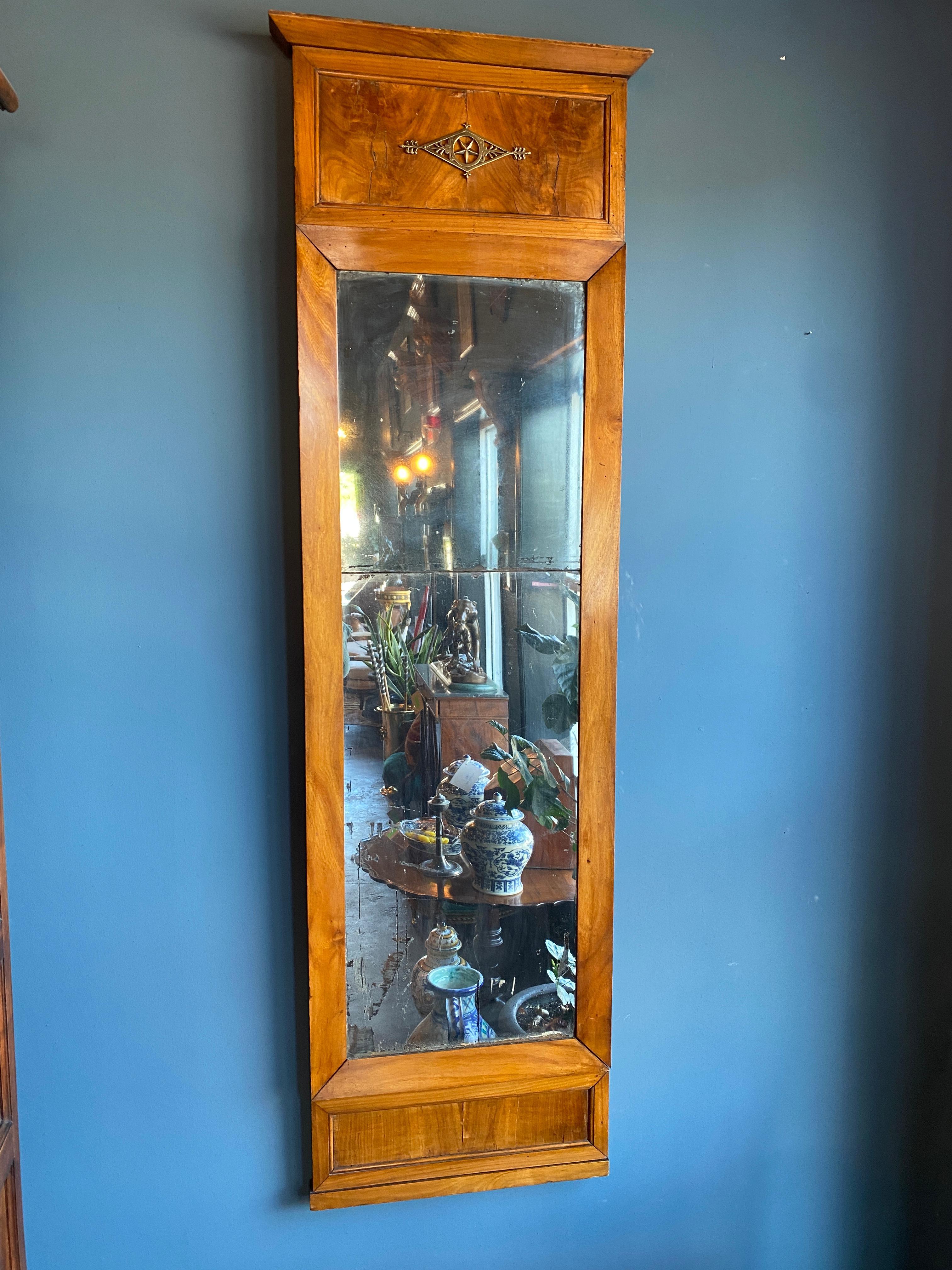 Deutscher Biedermeierspiegel aus dem frühen 19. Jahrhundert. Rahmen aus Kirschholz mit originalem Spiegel. Ein einzelner Bronzebeschlag auf der Oberseite. Originaler zweiteiliger Spiegel.