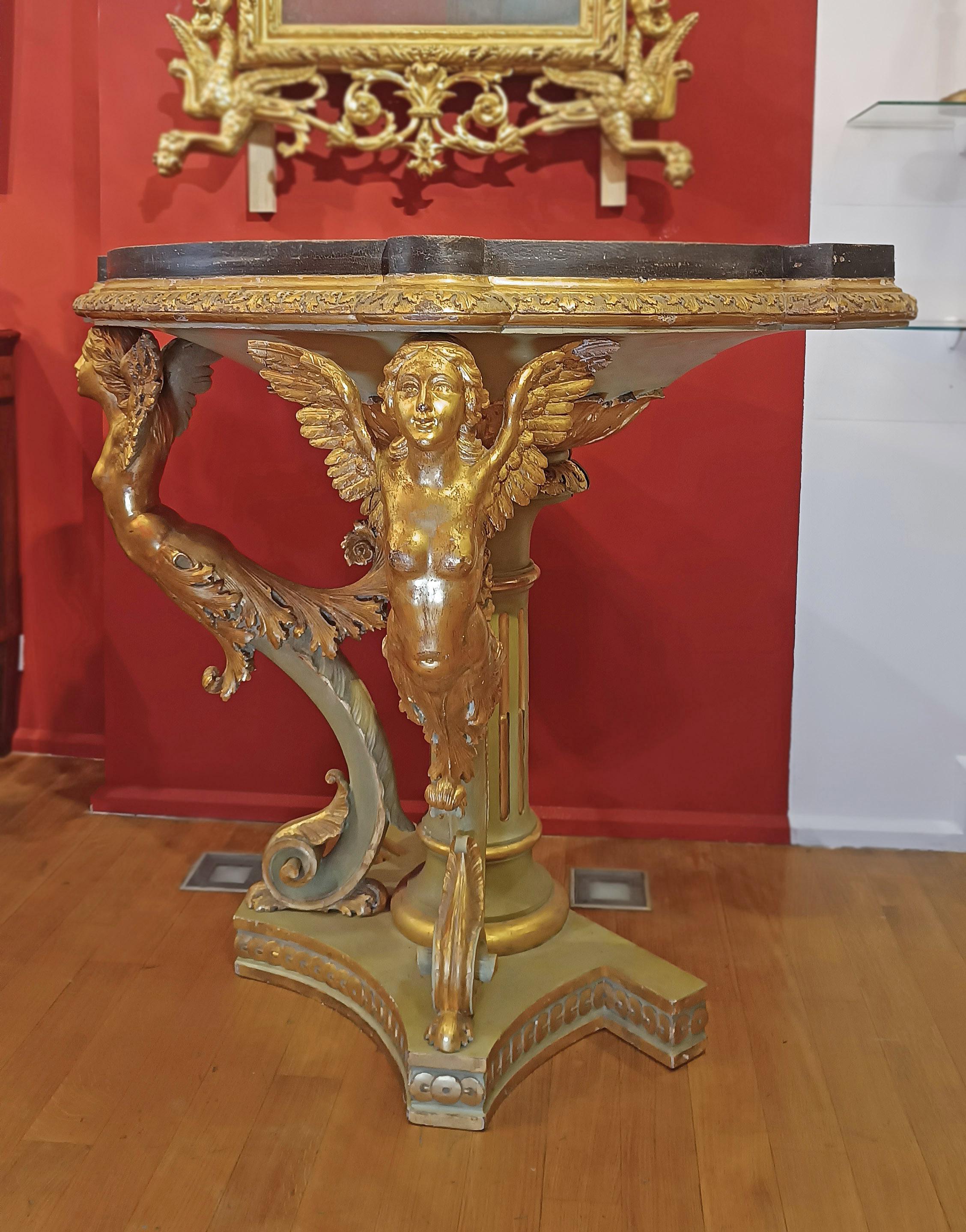 Elegant, slightly curved, half-moon console table, crafted from hand-carved wood, gilded with gold leaf, and painted. The console table features a geometric base and a columned shaft, painted sage green and embellished with gilded details. Further