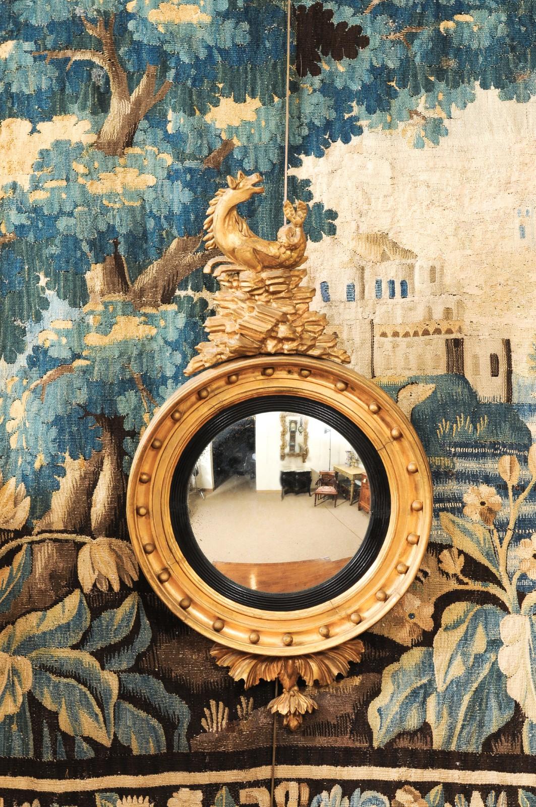 Espejo de ojo de buey de madera dorada de principios del siglo XIX con cresta mitológica tallada de hipocampo/caballo marino
