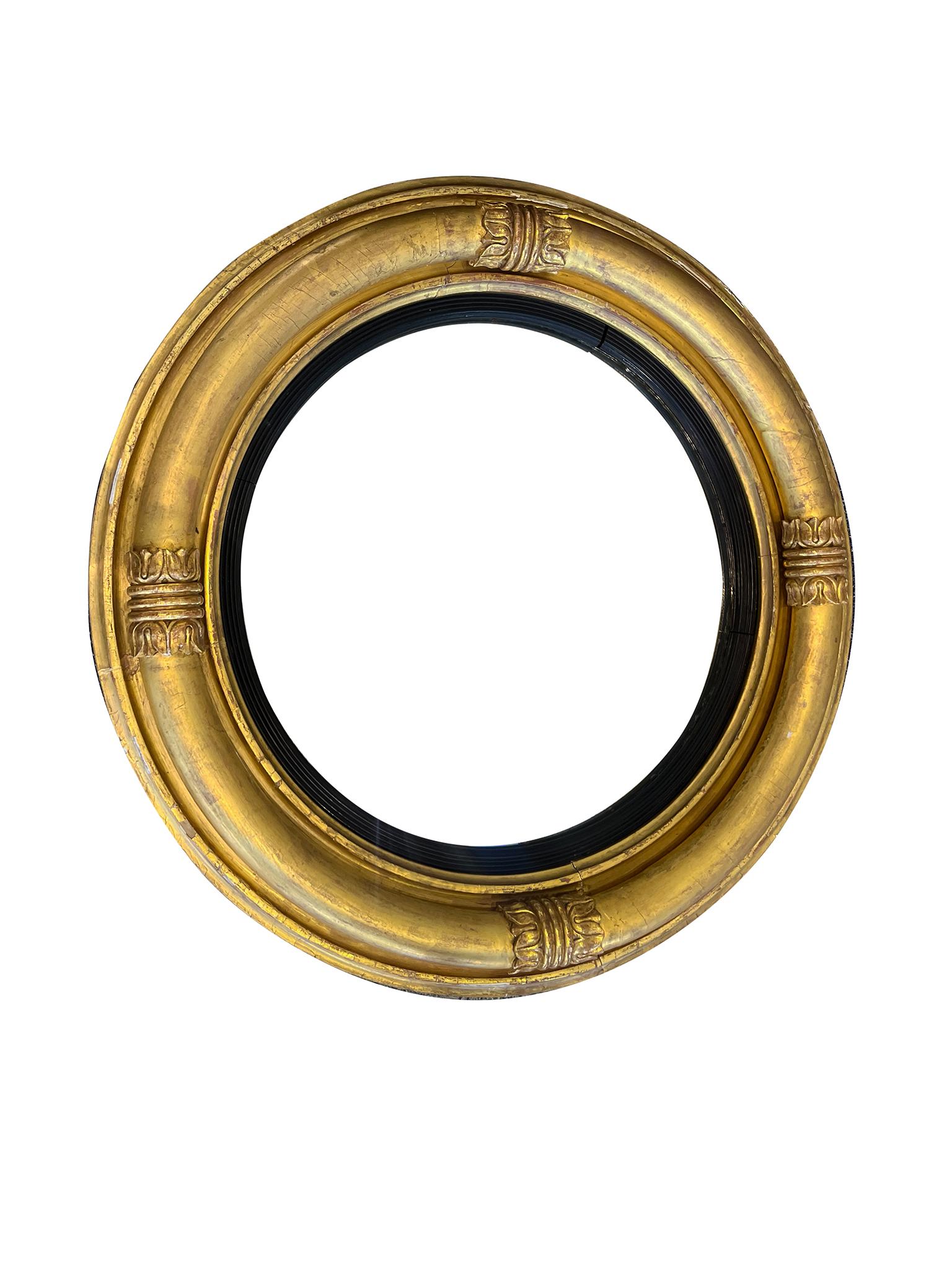 Fabriqué à la main au début du 19e siècle, ce miroir anglais antique à œil de bœuf se distingue par son élégant cadre en bois doré et sa construction à double anneau. Un Label au dos indique que le sculpteur et le doreur est H. Braithwaite. Il