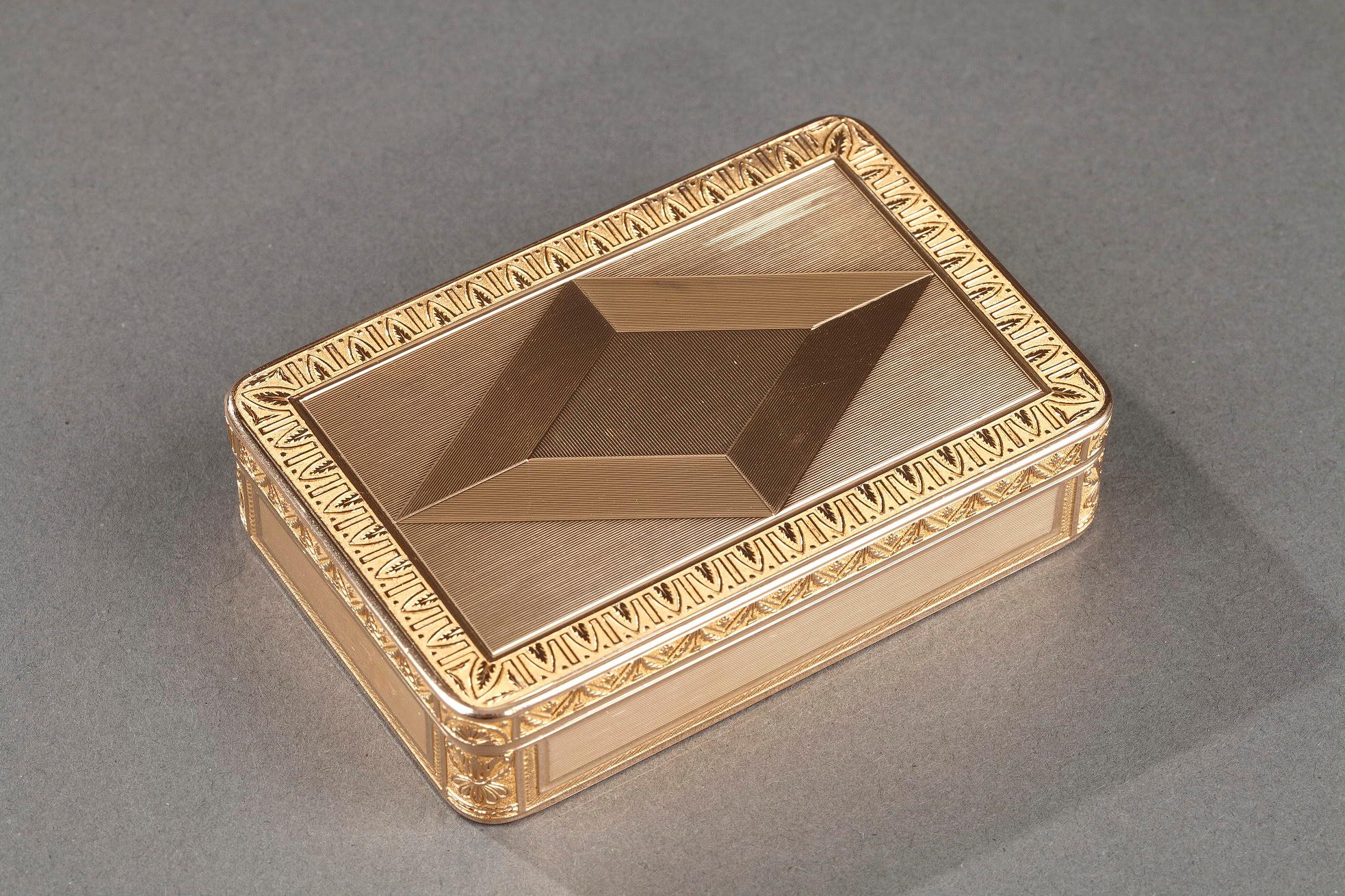 An important rectangular gold snuff box with rounded corners. The hinged cover is decorated with parallel strips forming a diamond pattern. The cover and base panels are adorned with palmette patterns on a matte background. The box is decorated with