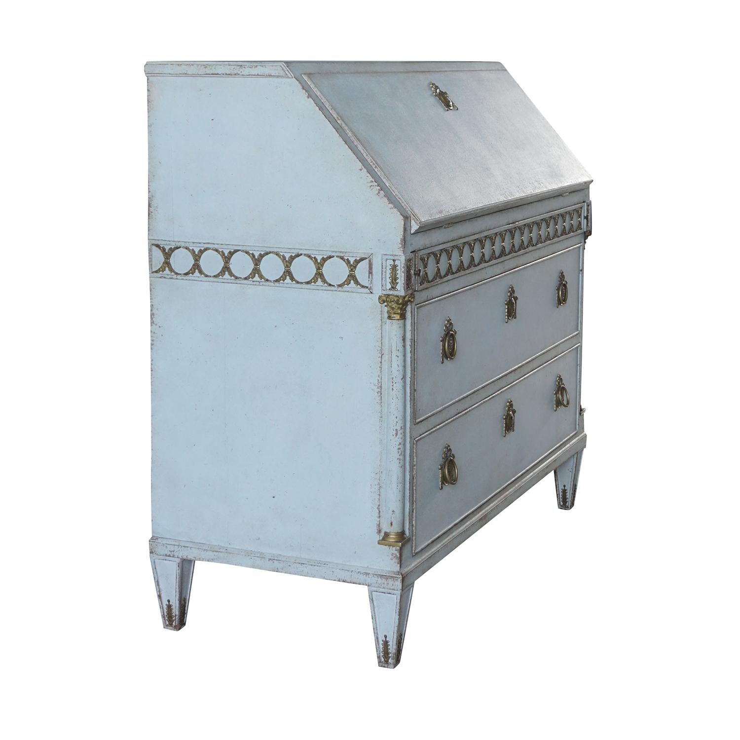 A light-blue, antique Swedish Gustavian bureau, table made of light grey painted Pinewood with a beautiful brass and bronze decoration. The hand carved Scandinavian writing desk is in good condition, detailed in the Neoclassical Greek style with the