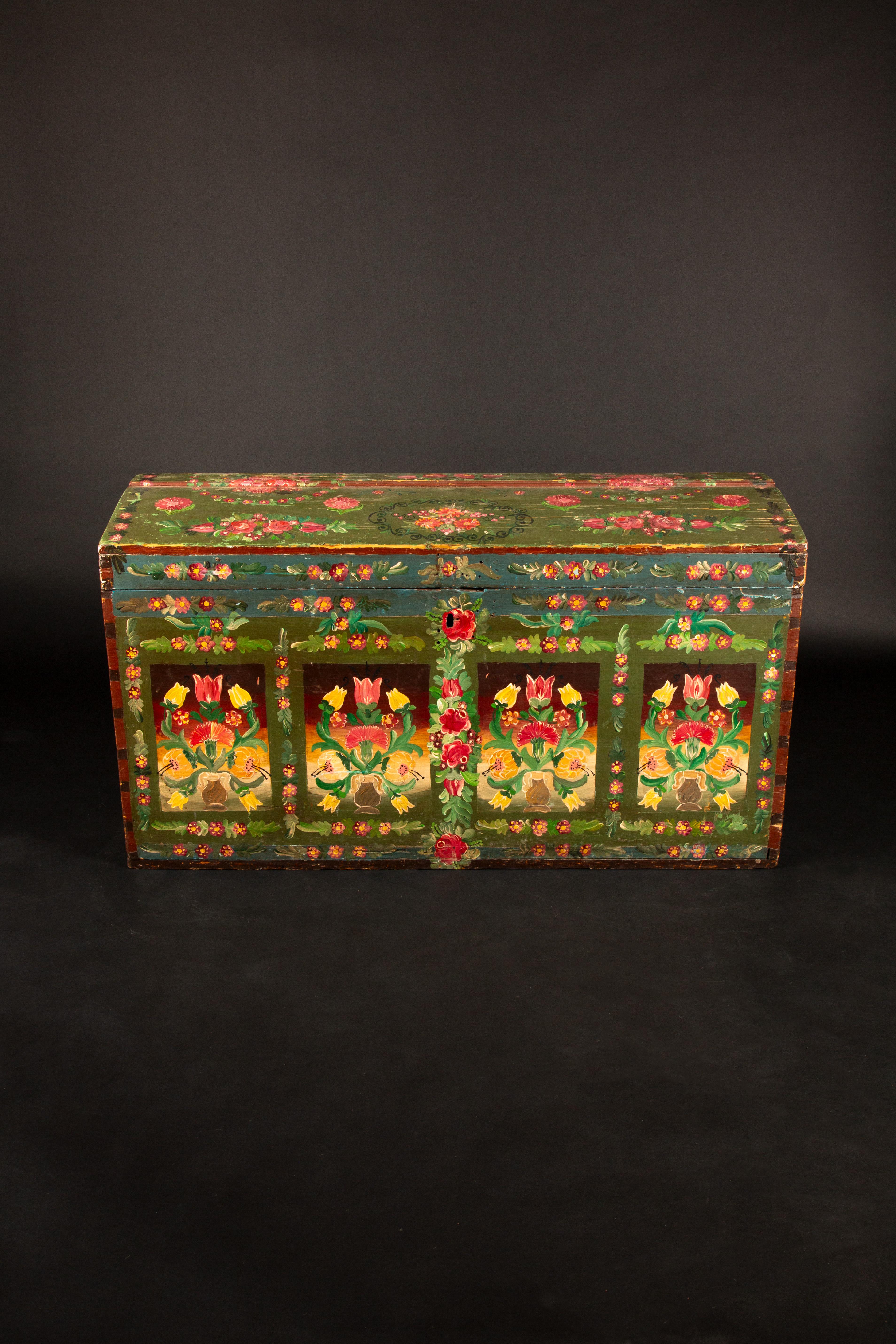 Questo squisito baule dipinto dell'inizio del XIX secolo mette in mostra la maestria e l'artigianato dell'epoca. Adornato con vivaci motivi floreali, principalmente rose e tulipani, questo pezzo cattura l'essenza dell'arte popolare tradizionale. Lo