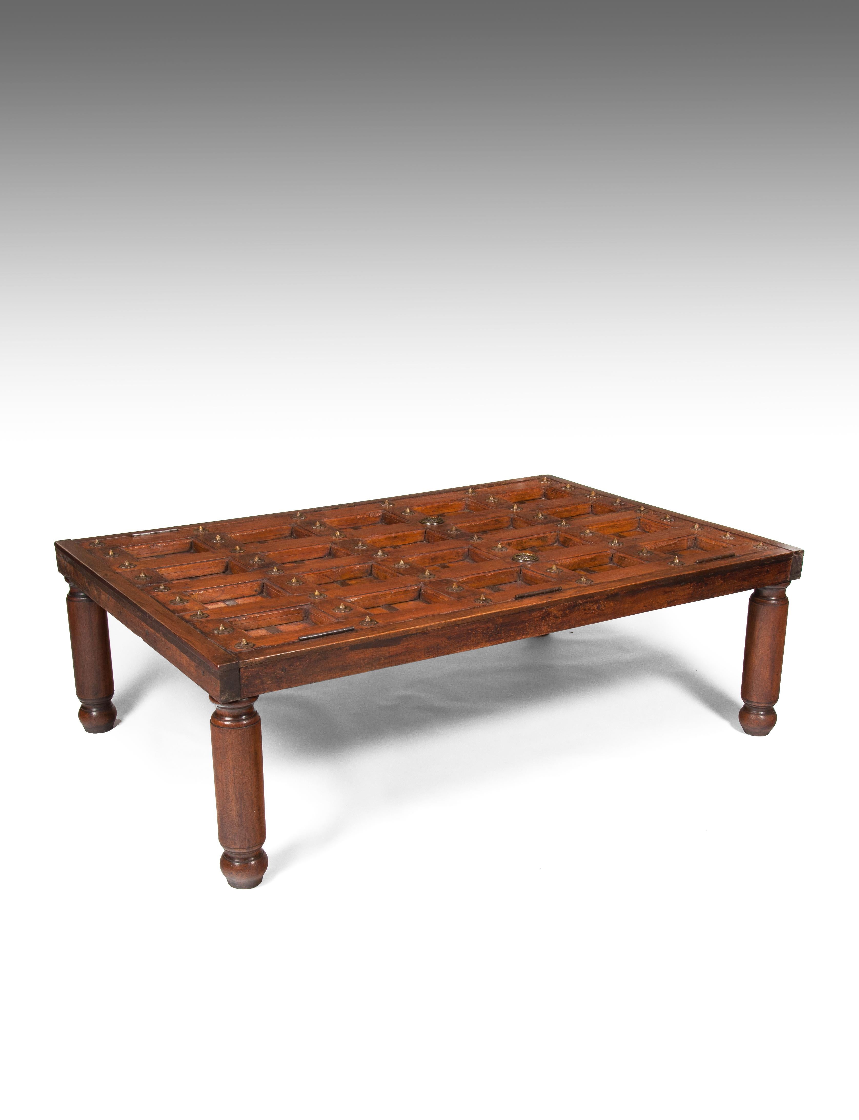 A superb early 19th century teak Indian entrance door converted into a coffee table.

Indian, circa 1820-1830.

Having a wonderful patina and coloring this entrance door would have been the front doors to an Indian fortress.
Made from solid