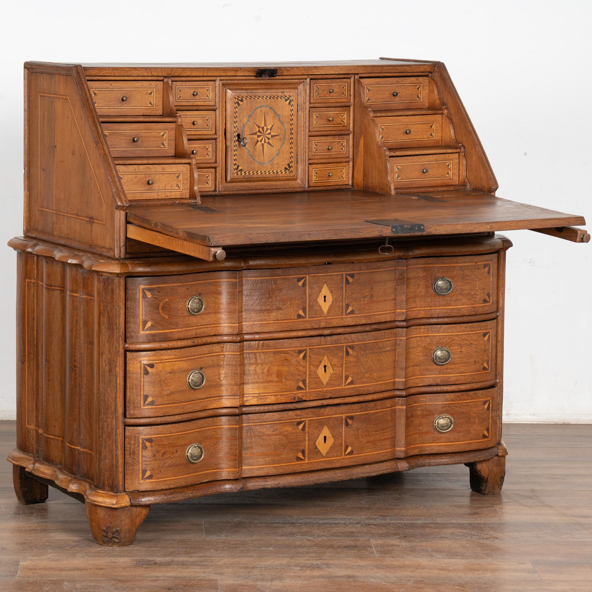 The warm patina of the aged wood glows with life in this lovely rococo secretary or bureau with striking inlaid double star pattern along desk front.
The interior 14 drawers and one central cubbie with petite door create an inviting interior work
