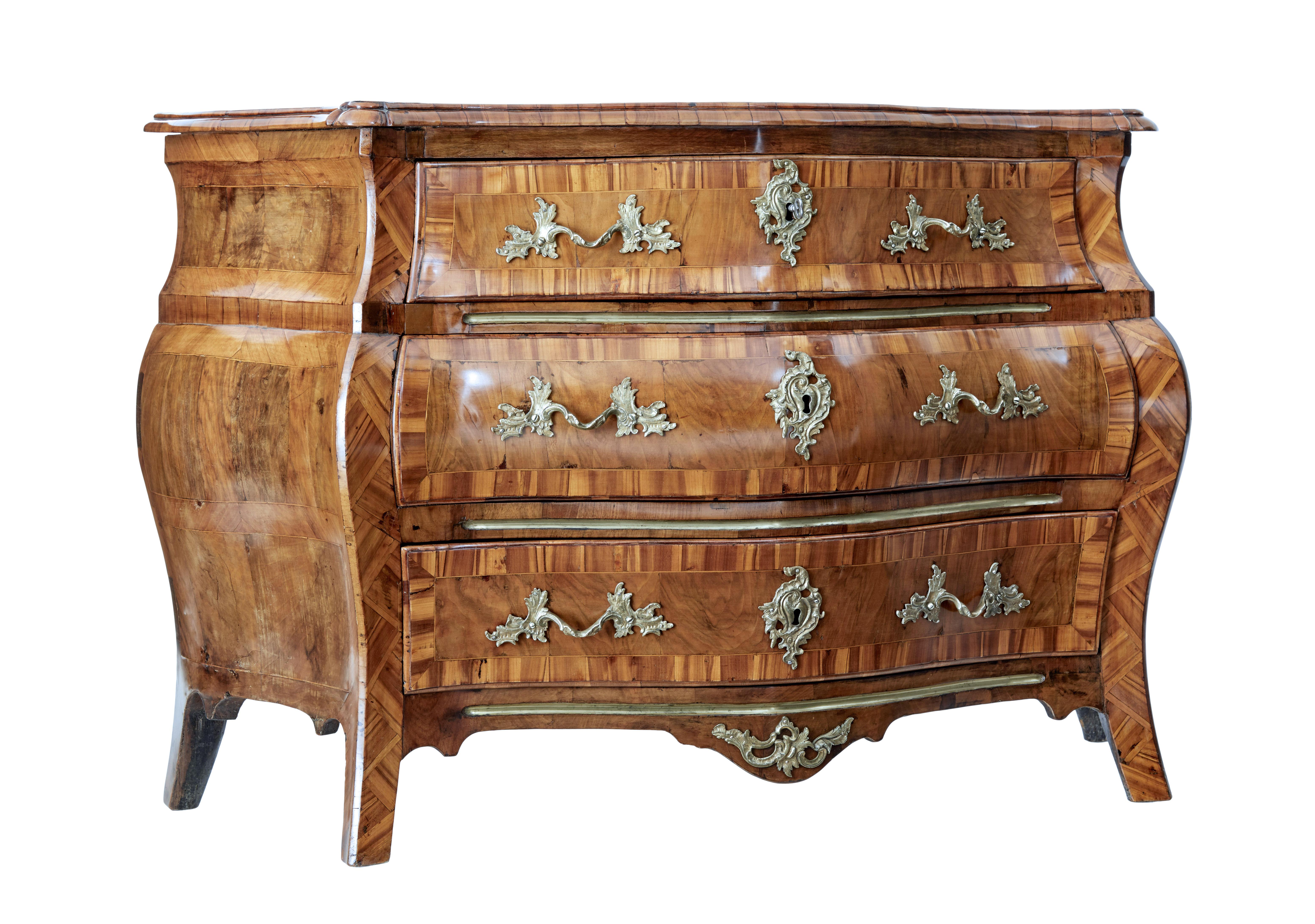 Early 19th century inlaid walnut bombe chest of drawers circa 1800.

Fine quality Swedish rococo revival commode with the typical bombe shape of bulging out in the middle and curving in at the base.

Shaped walnut top surface with patches to