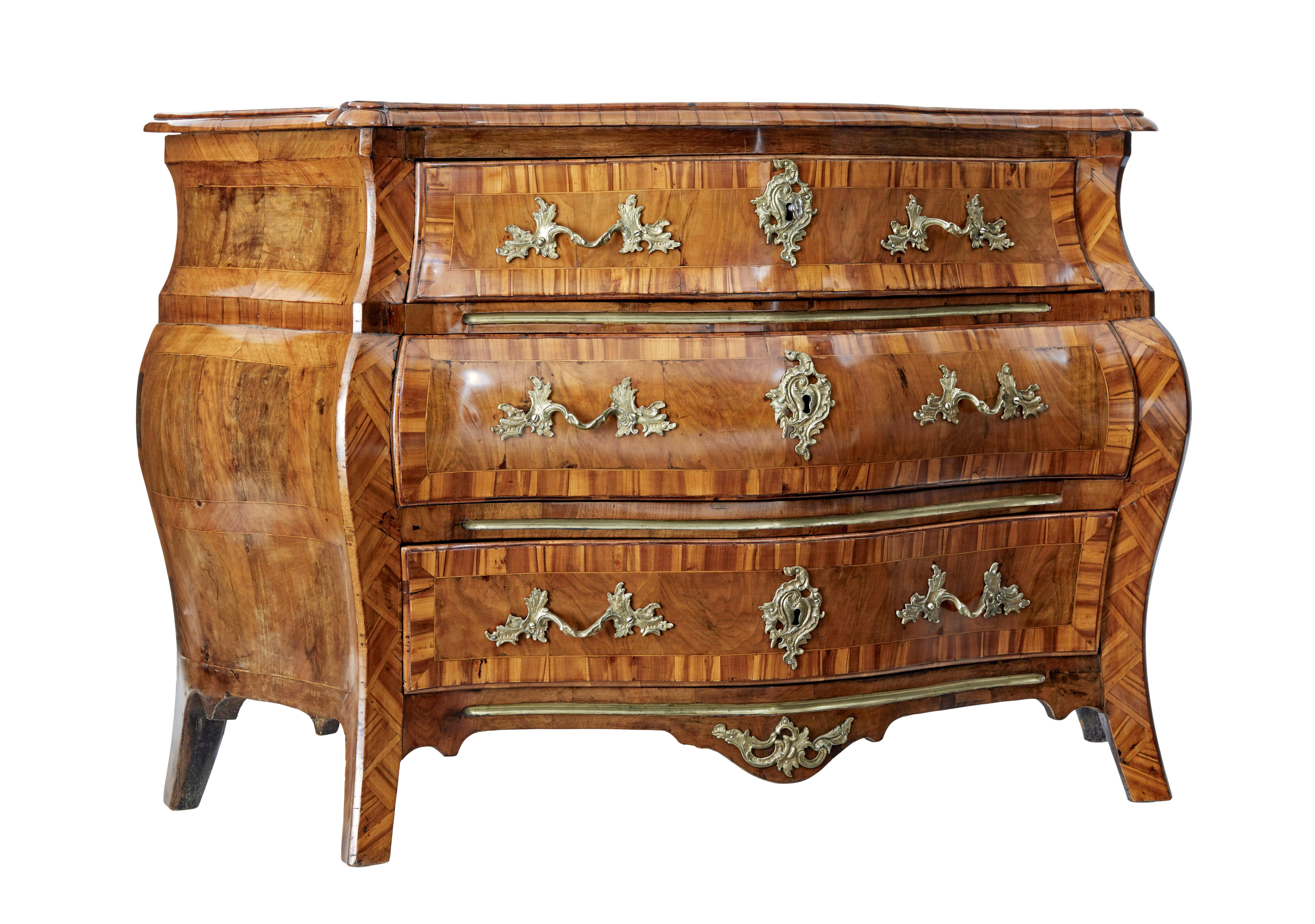 Early 19th century inlaid walnut bombe chest of drawers circa 1800.

Fine quality Swedish rococo revival commode with the typical bombe shape of bulging out in the middle and curving in at the base.

Shaped walnut top surface with patches to replace