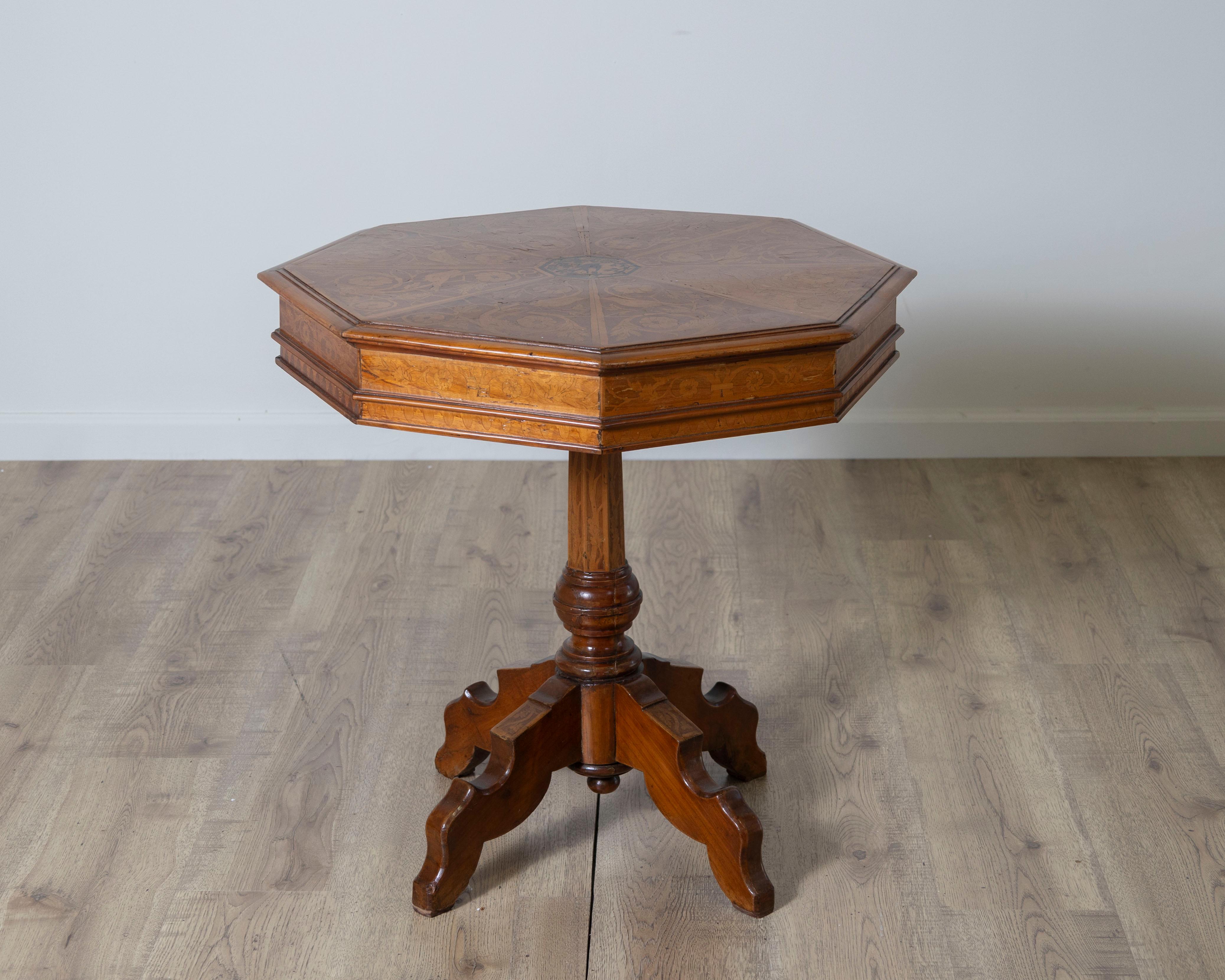 Exemple remarquable de l'artisanat toscan, cette table d'appoint italienne du début du XIXe siècle est construite en noyer richement grainé et ornée d'incrustations exquises en bois clair. Le plateau octogonal est décoré de panneaux losangiques