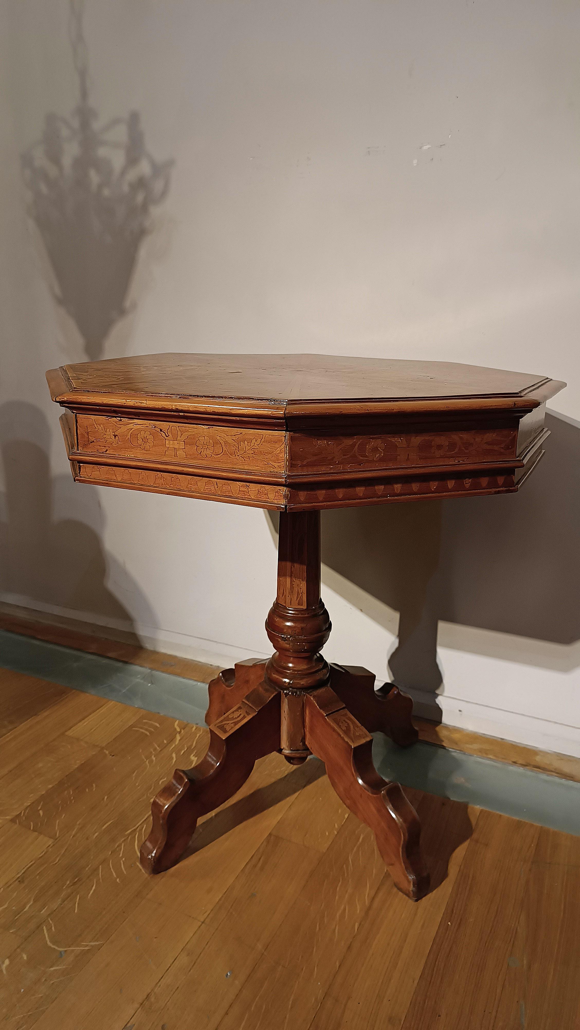 Beautiful walnut coffee table, decorated with refined light wood inlays that adorn the band, top and legs. The top has an octagonal shape with elegant lozenge inlays and vegetal motifs, and in the center a graceful little bird in ebonized wood. The