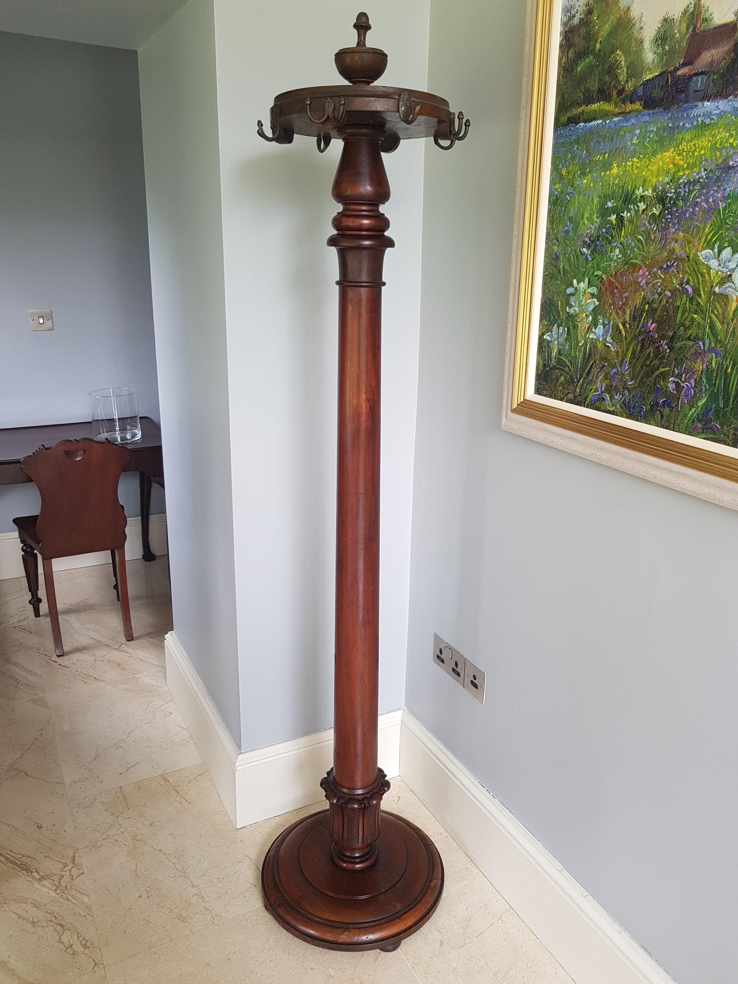 An Irish early 19th century tall mahogany coat rack with bronze hooks, featuring a central cylindrical mahogany column terminating on a round base.

Constructed very much in the style of early Irish 19th century furniture by Mack, Williams and
