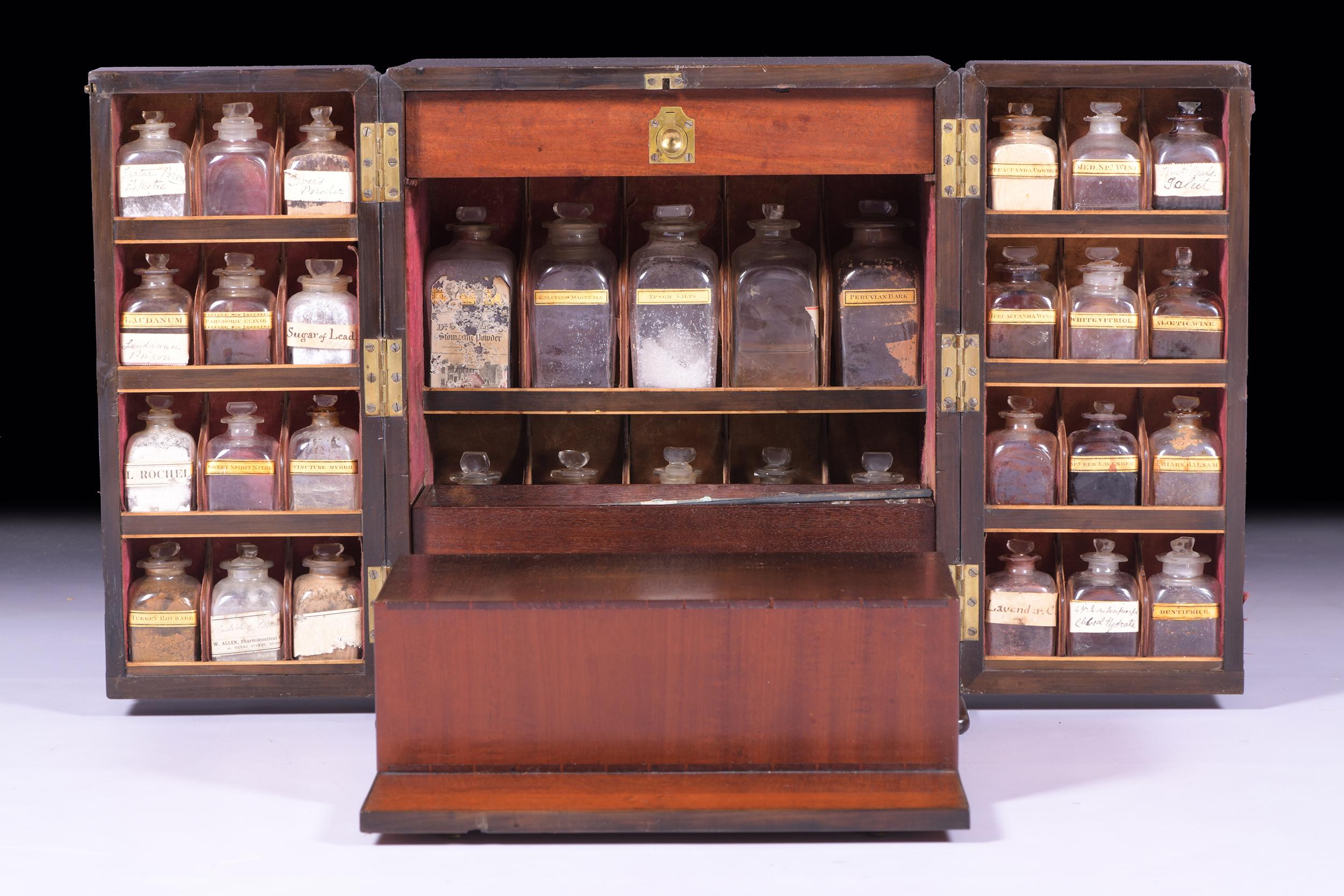 An exceptional early 19th century mahogany apothecary cabinet medicine chest with brass carrier handles to each side which opens through the double doors to reveal an arrangement of bottles, with labels and contents, partially full apothecary