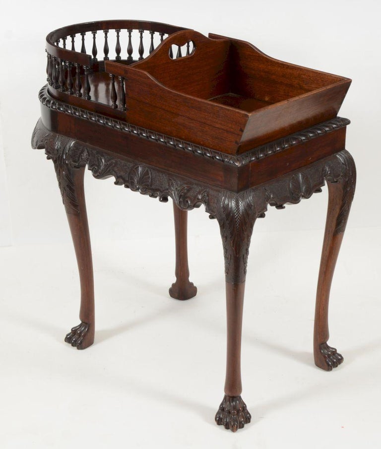 Georgian mahogany serving table, Irish. The top fitted with a tray configured with a rounded gallery end for dishes and a canted box for flatware. The base with a gadrooned edge above a finely carved apron with shell and foliate decorations on