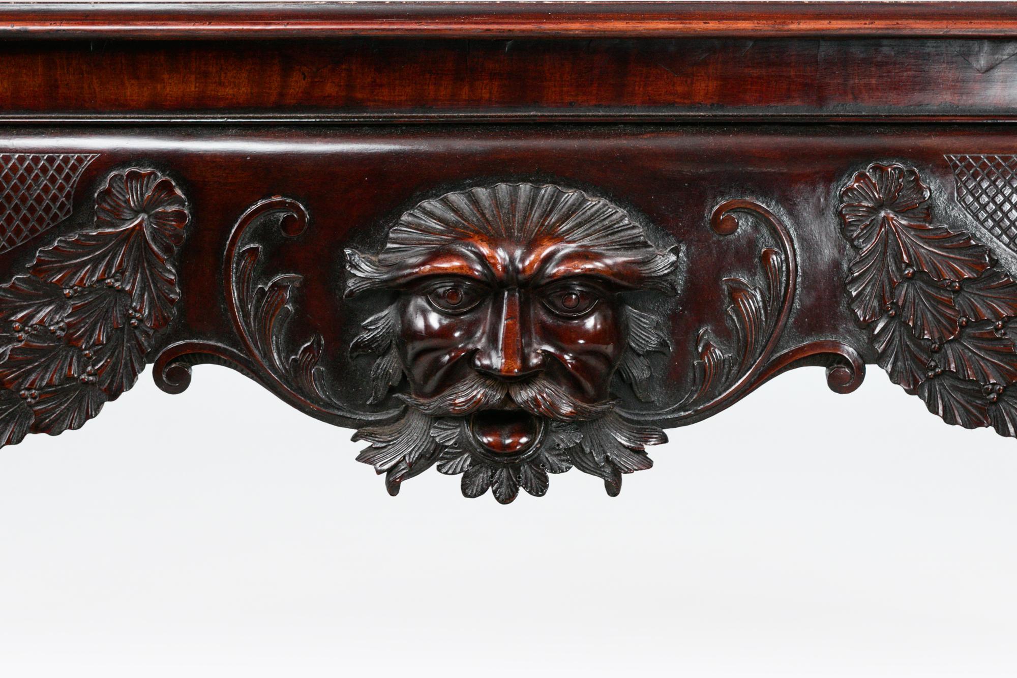 Table d'appoint en acajou irlandais du début du 19e siècle, avec une frise minutieusement sculptée représentant un masque flanqué de guirlandes florales, soutenue par des pieds cabriolets se terminant par des pieds en patte de lion sculptés.