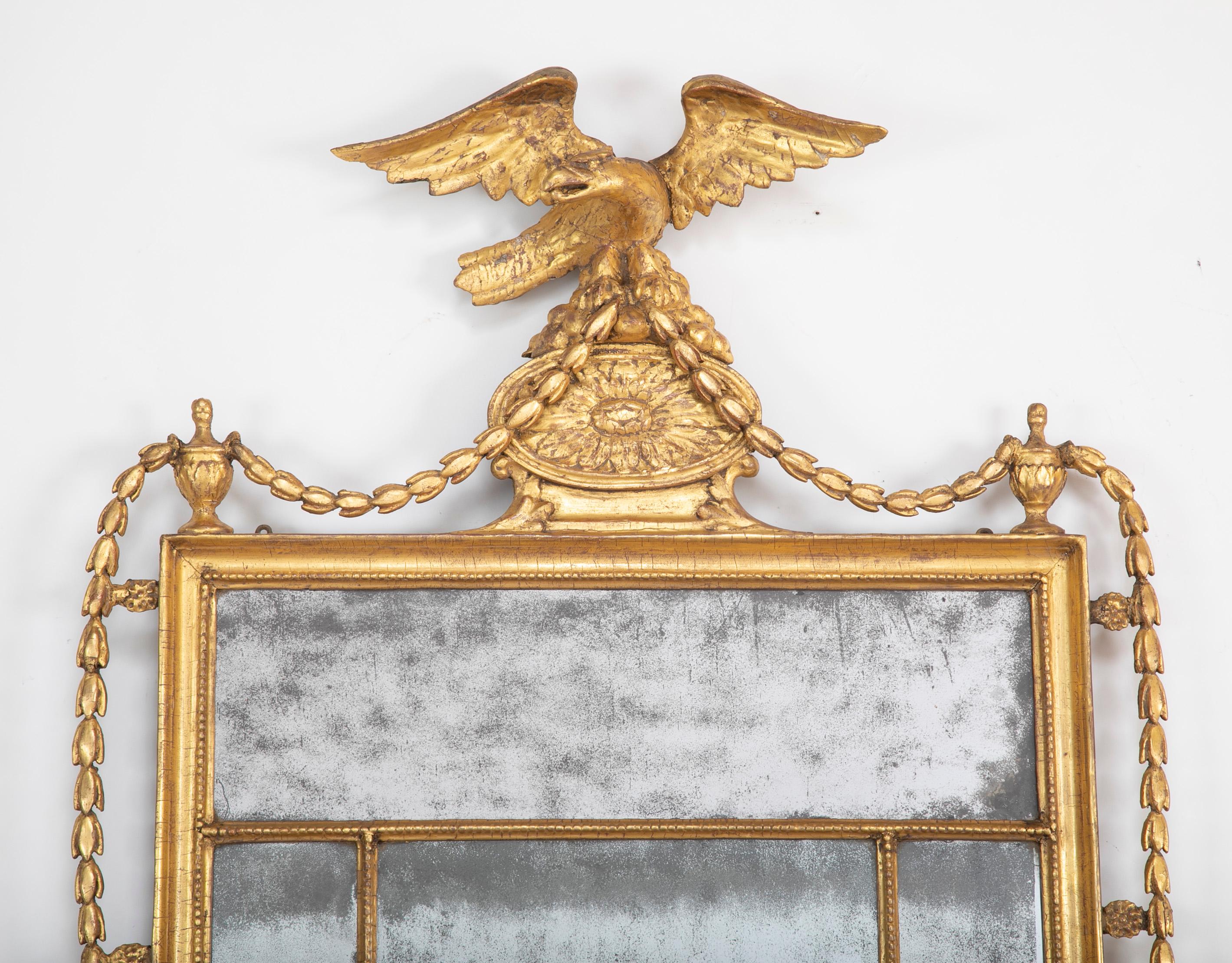 Early 19th century Irish or English giltwood mirror with eagle and old, probably original, glass panels, circa 1810-1815.

FW 1675.