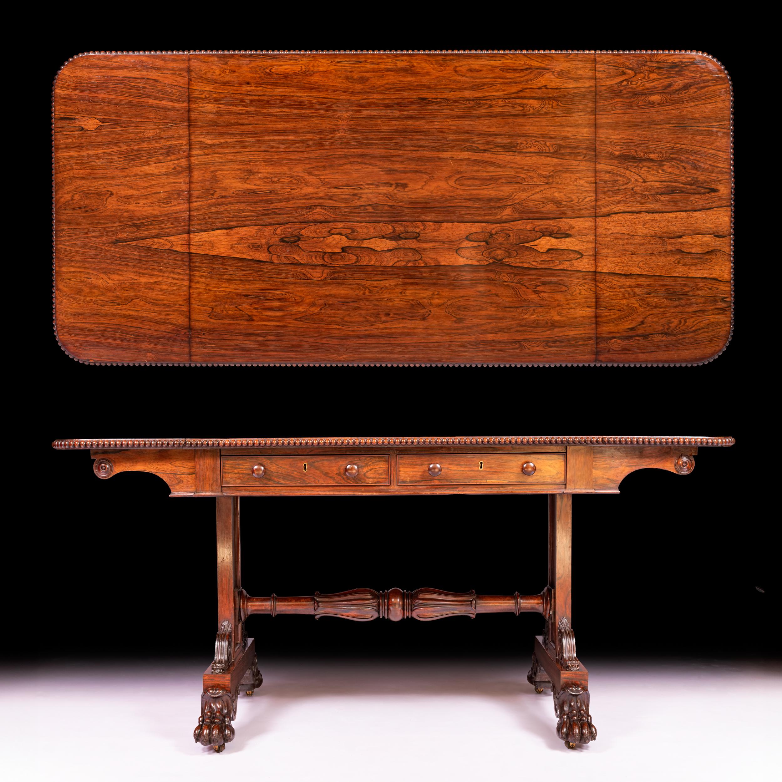 A stunning quality Irish Regency Gonzalo Alves sofa table attributed to Gillingtons of Dublin, the rounded rectangular hinged top with beaded edge, above a pair of frieze drawers with opposing simulated drawers, on end supports joined by a baluster