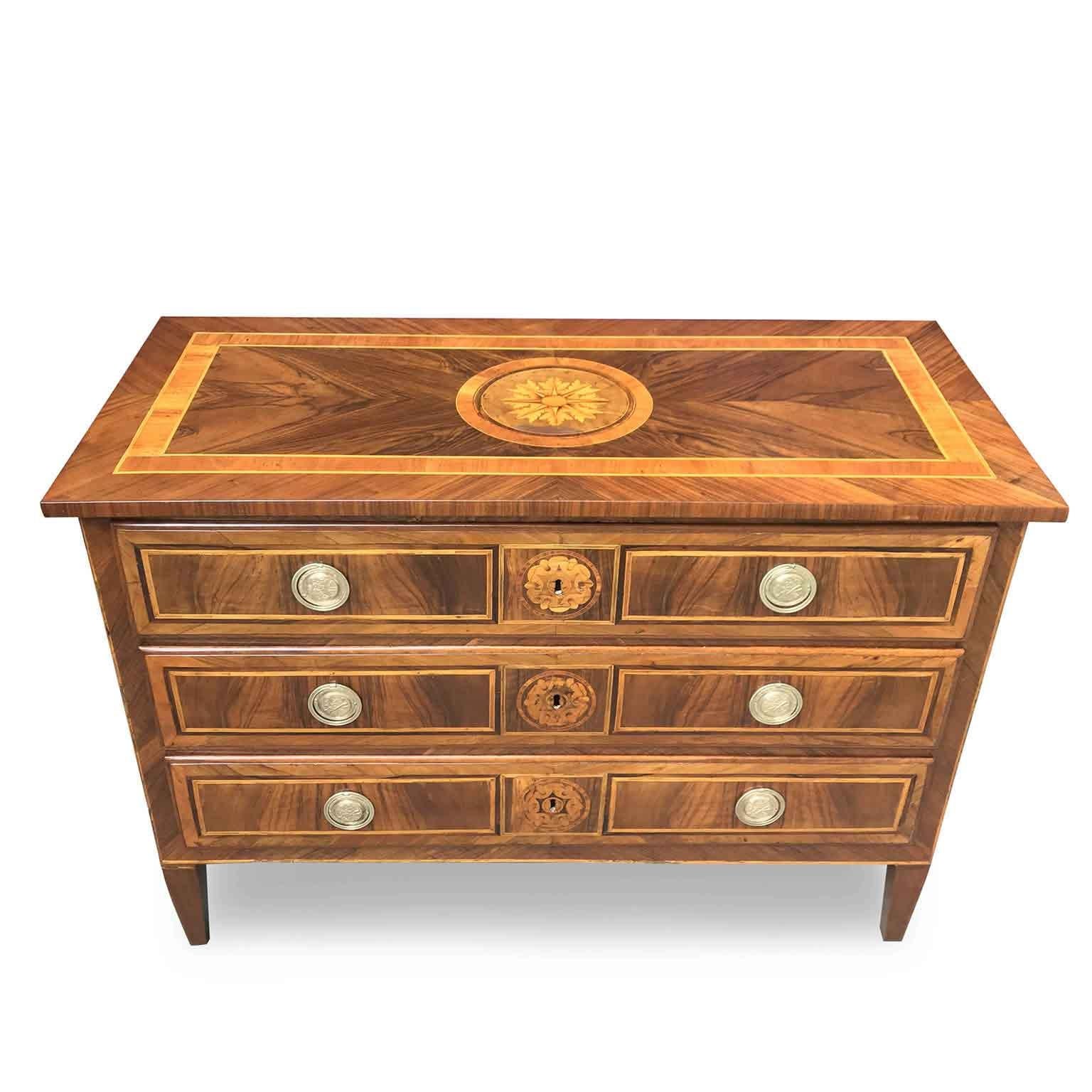 Beautiful rose Marquetry in this Italian Directoire three drawers commode dating back to the early 19th century, in good age related condition.
Top with an inlaid rose window in the middle, walnut veneered and inlaid with three drawers on the front.