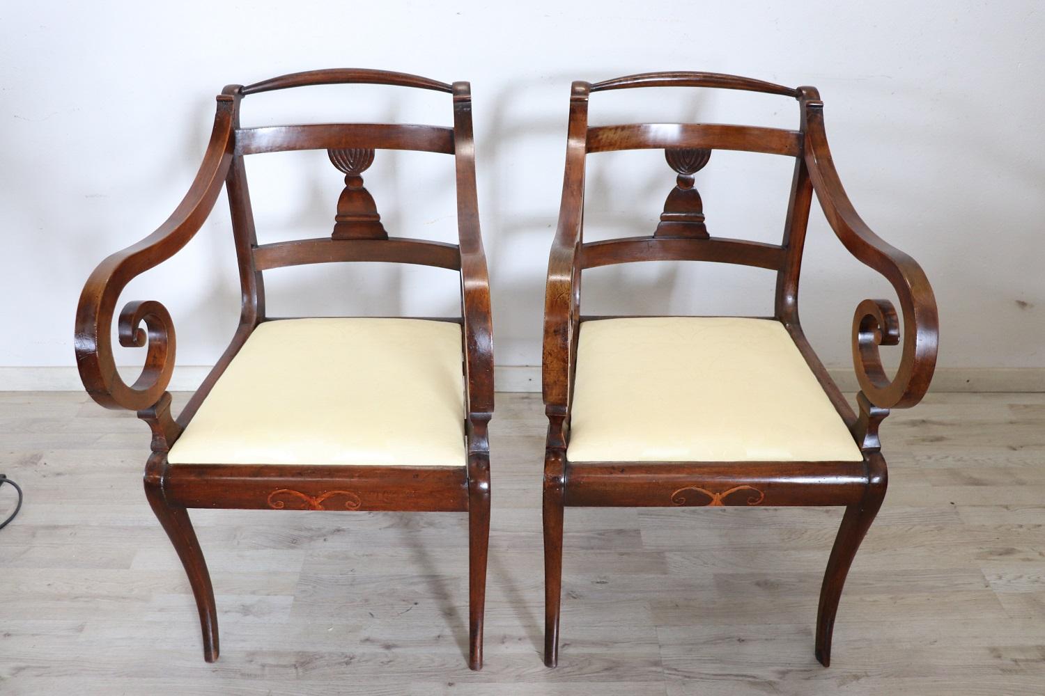 Lovely Italian antique armchairs, set of 2, 1800. These armchairs are of the period Empire in solid walnut wood. The seat Upholstered in fabric. Beautiful swirl armrests. This beautiful armchairs has an enveloping shape and a comfortable seat. Good