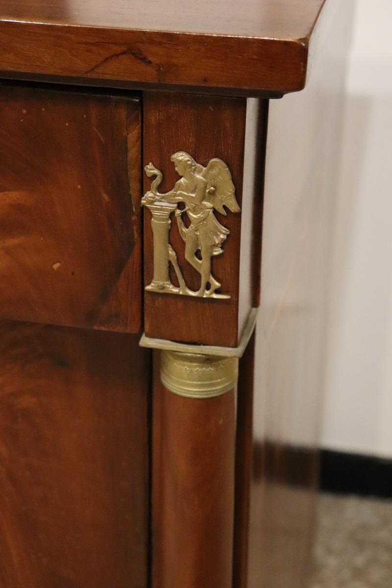 Nous vous présentons cette élégante commode italienne ancienne datant du début du 19ème siècle, période Empire. Une commode extrêmement raffinée, dont les caractéristiques suggèrent qu'elle a été fabriquée dans les ateliers d'ébénisterie du nord de
