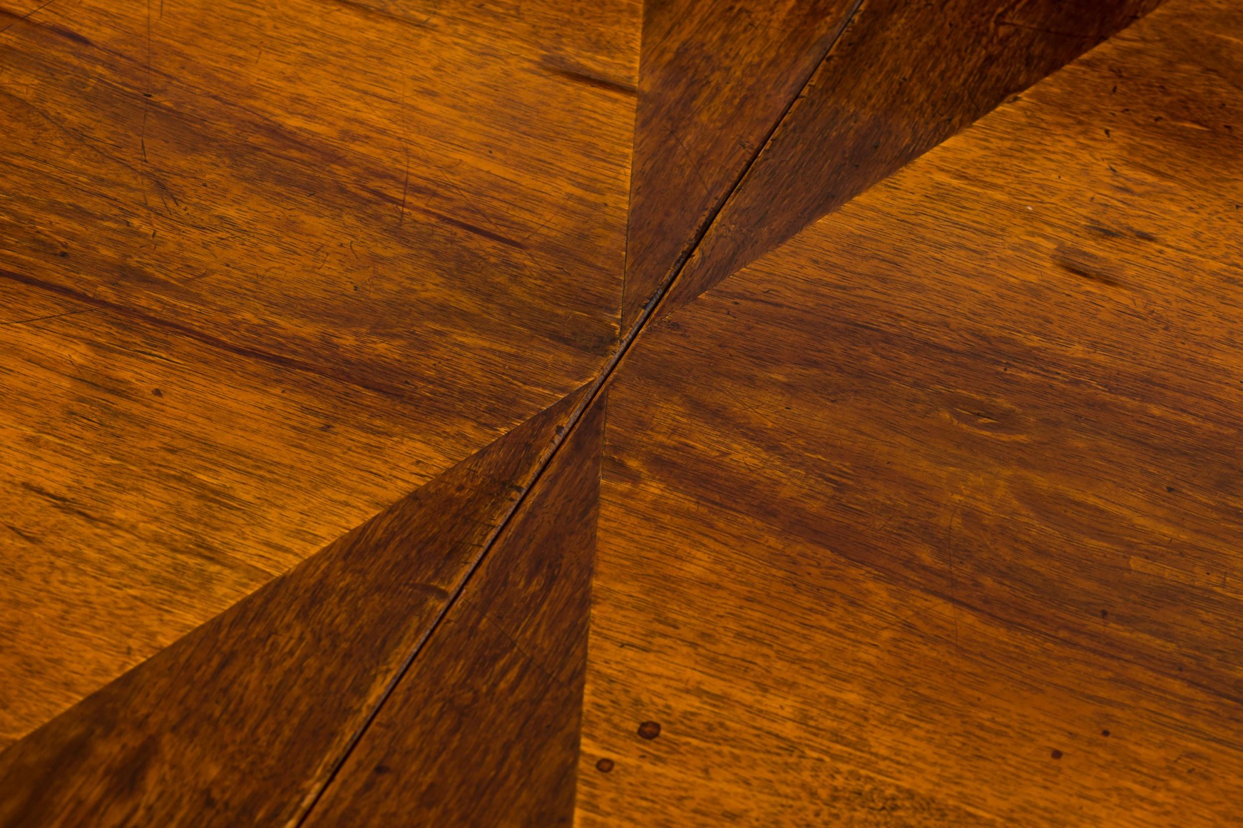 Italian Venetian (early 19th Century) burl walnut dining table standing on turned tapered legs, in circular form which extends to an oval with two additional diamond design veneered leaves which are supported by a centered substantial carved wood