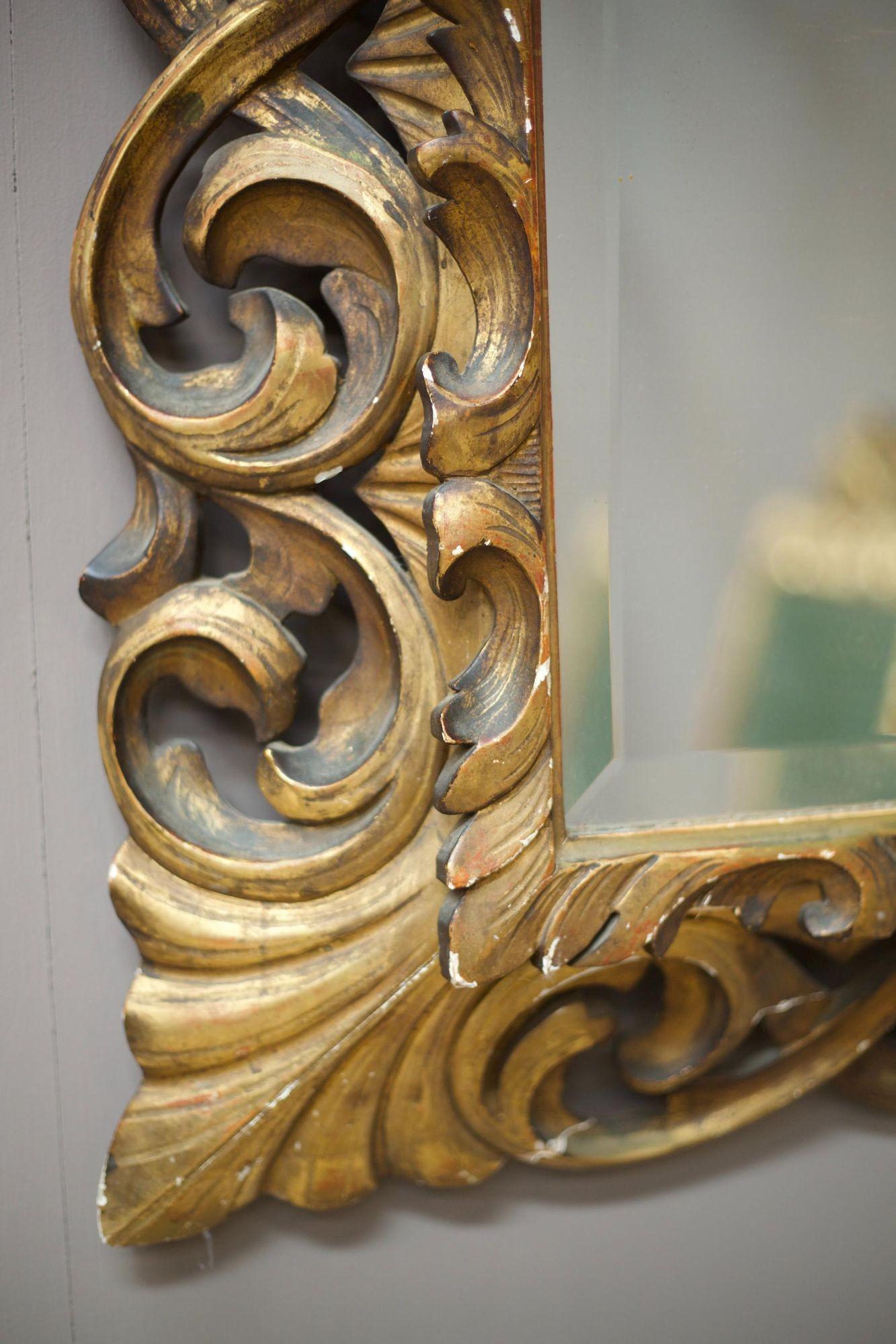 This is an exceptional early 19th century Italian Giltwood mirror in very good overall condition considering its fragile nature. This mirror is an impressive size and has a very clean mirror plate which looks to be original. The gilt decoration has