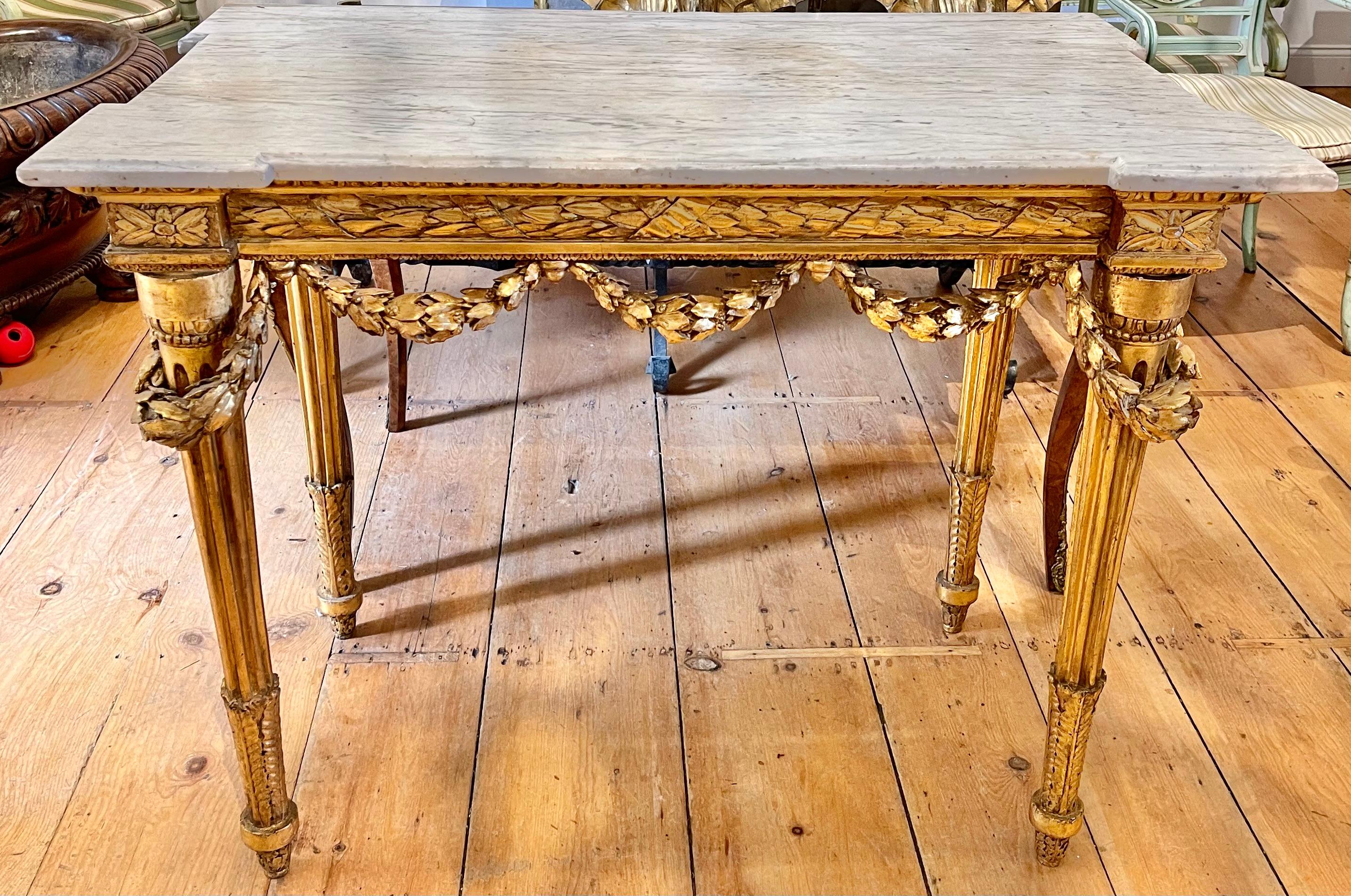 Period Italian neoclassical marble-top console table. Original gilt and marble. Lauren swags surround frieze of a laurel wreath. Round reeded tapered legs. A beautiful original piece.
 