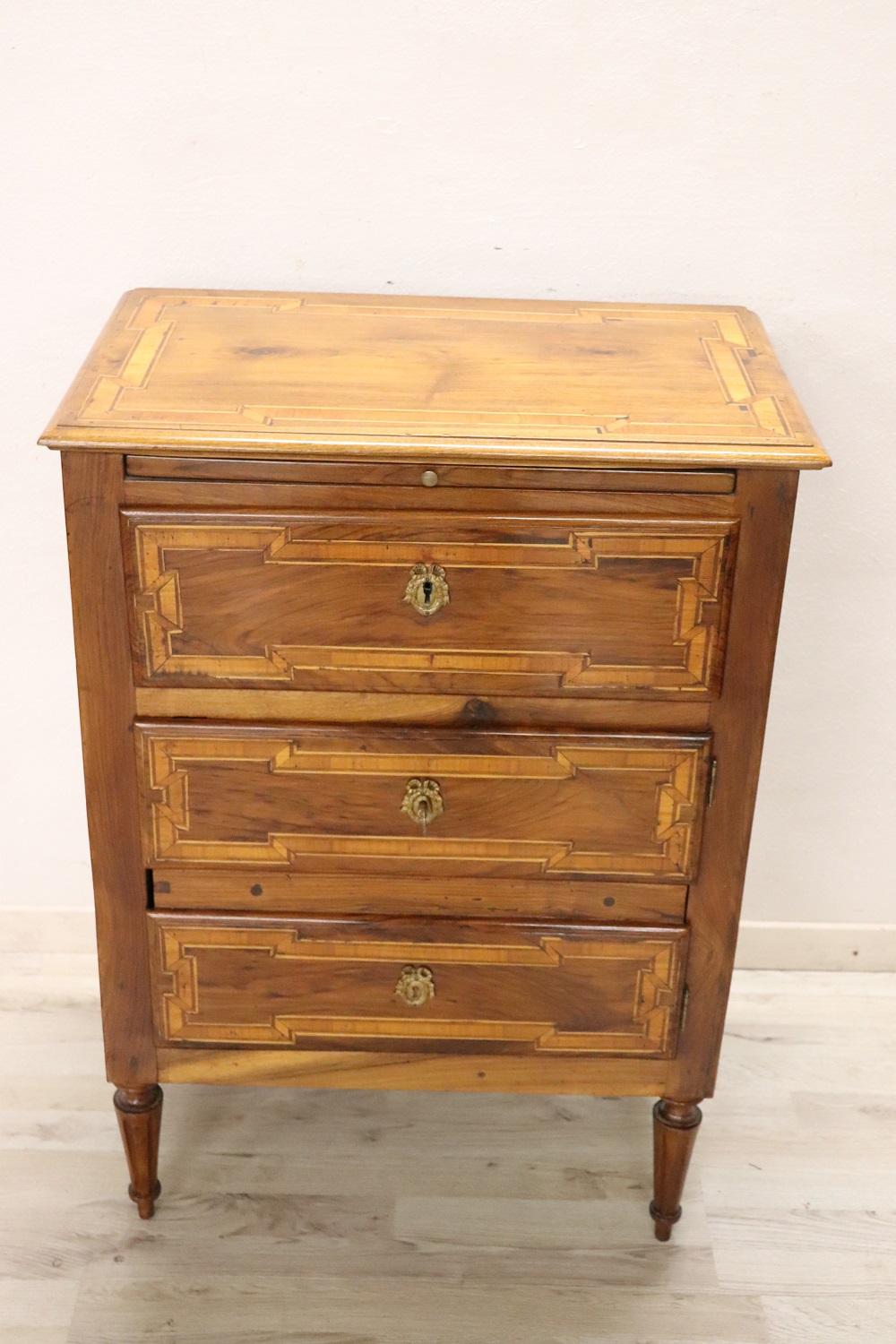 Lovely Italian Louis XVI style small chest of drawers, early 19th century in solid walnut wood. Inlaid decoration of geometric taste. On the front two fake drawers hide a large compartment available. Under the top there is an extractable top that