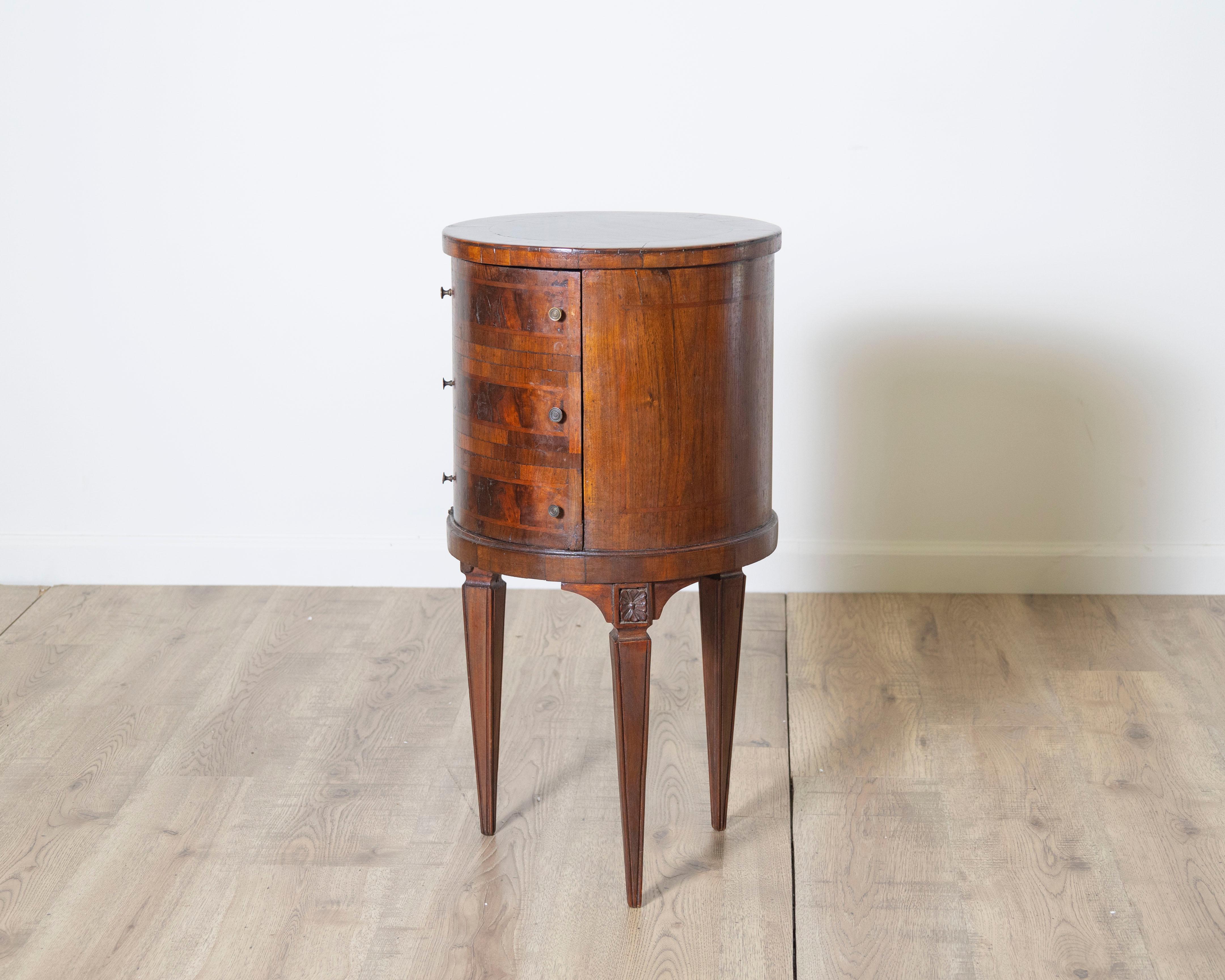Rare et charmante armoire circulaire de style Louis XVI, fabriquée en noyer richement fileté avec des proportions élégantes et des pieds finement effilés. Le corps cylindrique présente une façade subtilement incrustée avec des bandes décoratives et