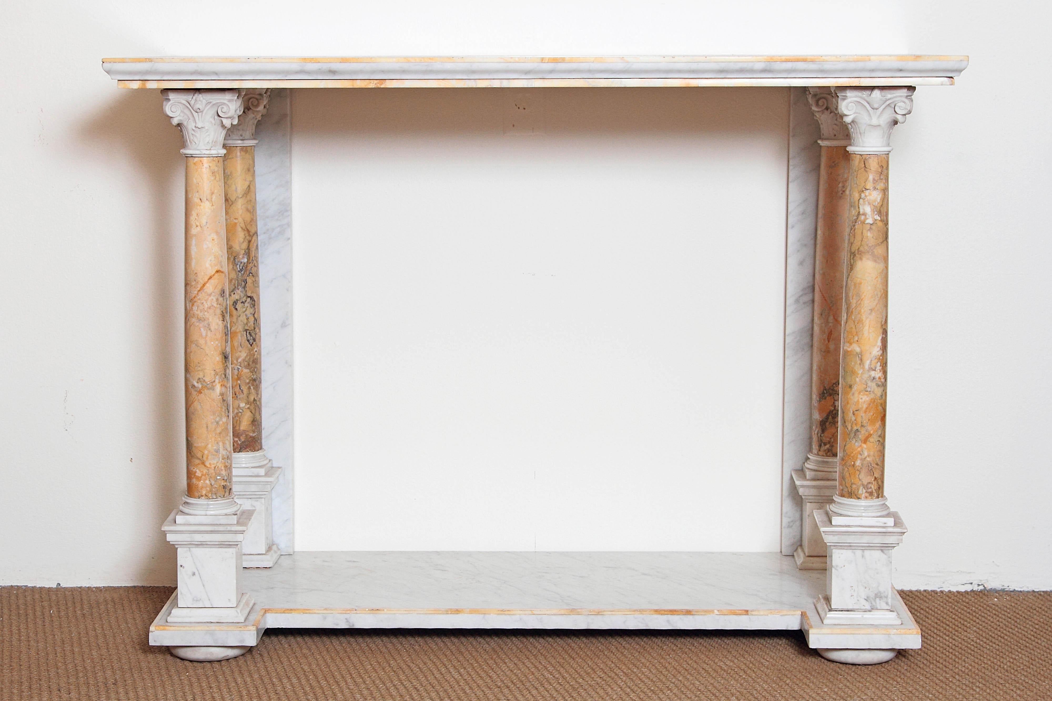 A stately marble console table. Top of white marble with 1/4 inch trim of tan marble. Four round beige marble columns with elaborate white capitals and bases set on lower shelf. The table comes apart into several pieces, early 19th century, Italy.