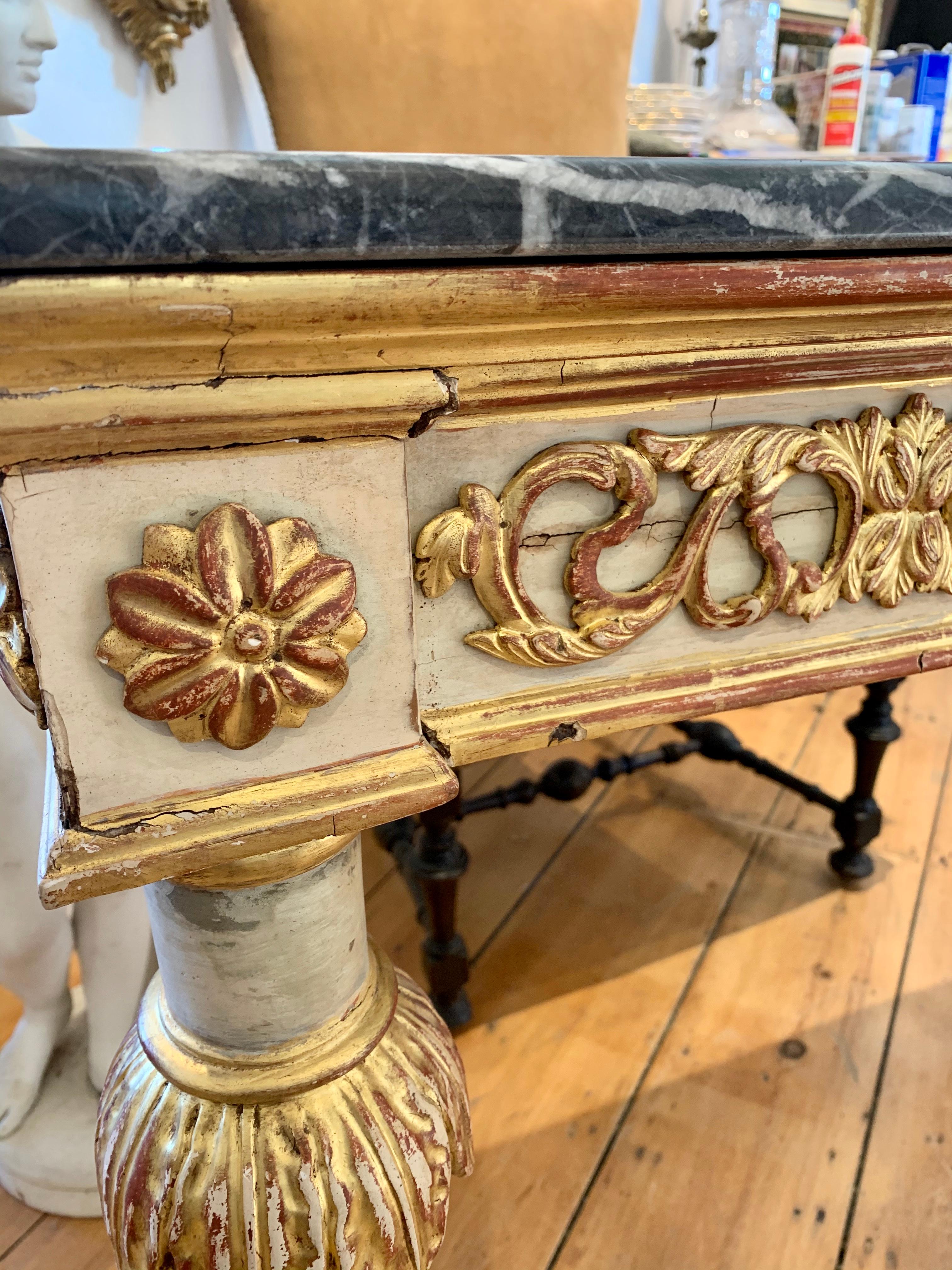 Period early 19th century Italian parcel-gilt console table with grey marble top and original giltwood carvings. Great size and stable construction.