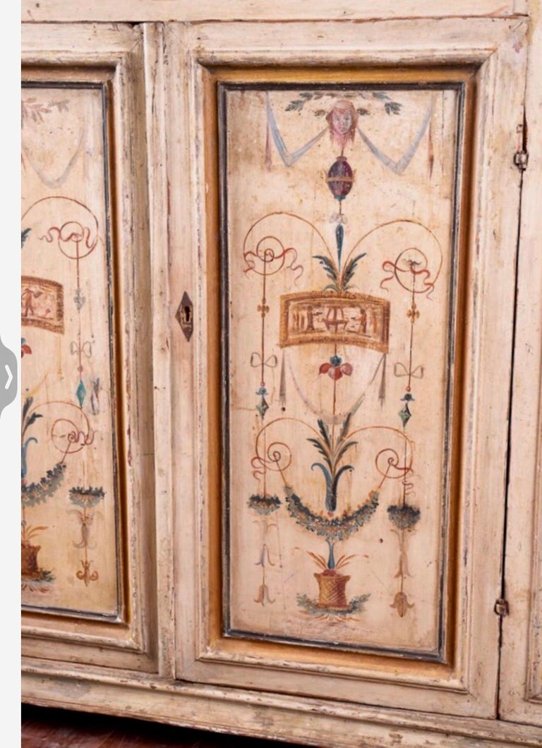 Beautiful 18th century Italian Tuscan Buffet. The Painted Images and the Vibrant Colors make this piece a standout. It is a very large storage piece with original shelves. The unusual shape is distinctive and the subtle colors will blend easily in