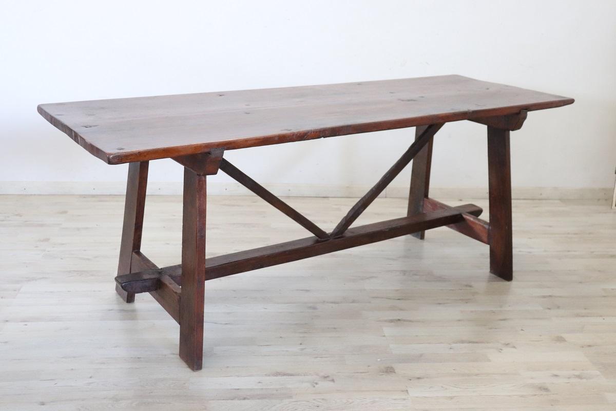 Nous vous présentons une majestueuse table de salle à manger rectangulaire italienne ancienne datant du début du 19e siècle. Cette table est fabriquée en chêne massif, son plateau rectangulaire est soutenu par des pieds à tréteaux, tandis que des