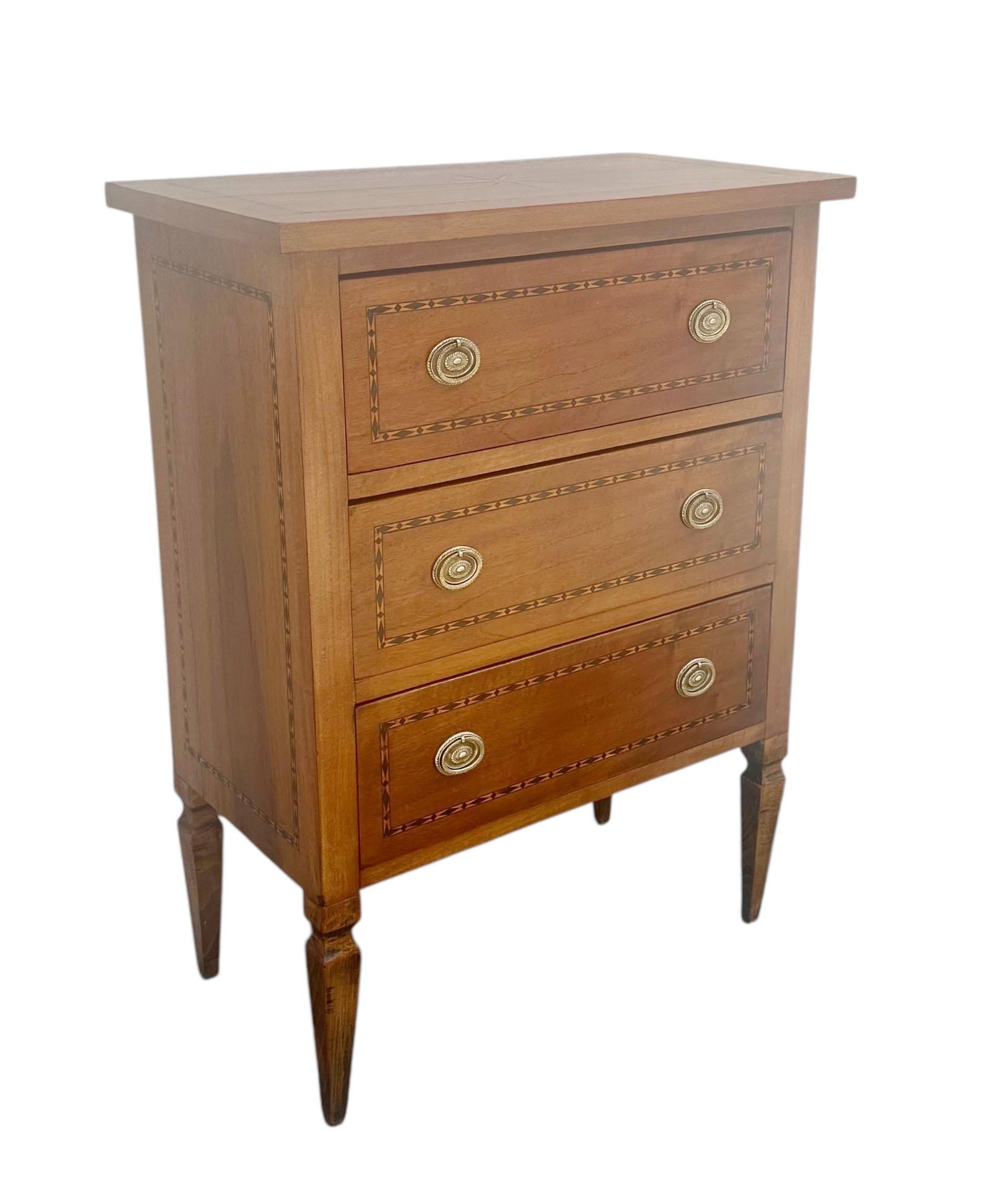An elegant Italian three-drawer chest, early 19th century, richly decorated with fine inlay work. The standout feature is the striking starburst motif at the center of the top, measuring six inches by eight inches, a detail that showcases the