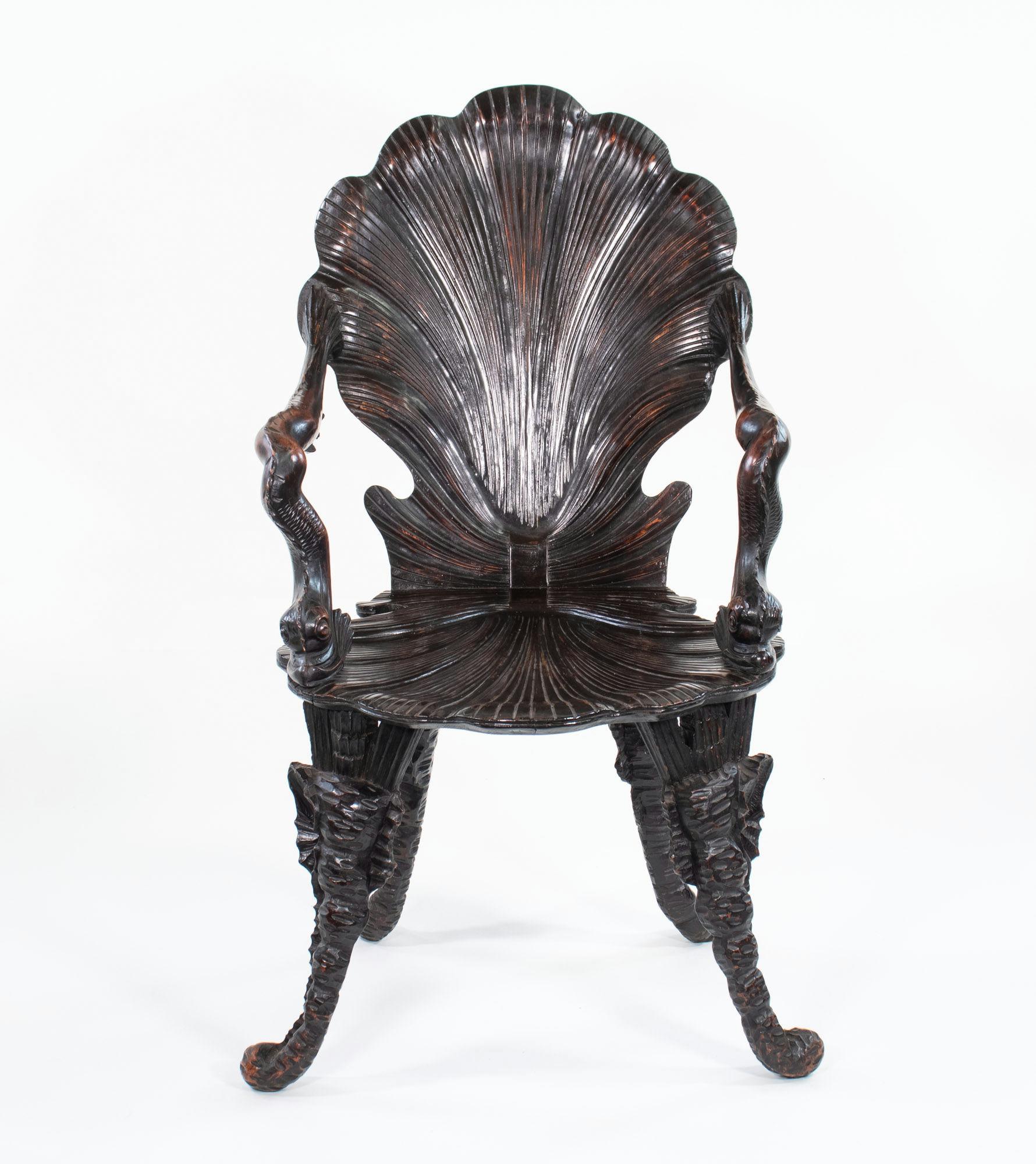 This whimsical 19th-century Venetian grotto chair is carved from gorgeous dark brown walnut. The piece features a large-scale open scallop shell motif on the back and seat, with sinuous curves and ridges throughout. The arms are stylized dolphins,