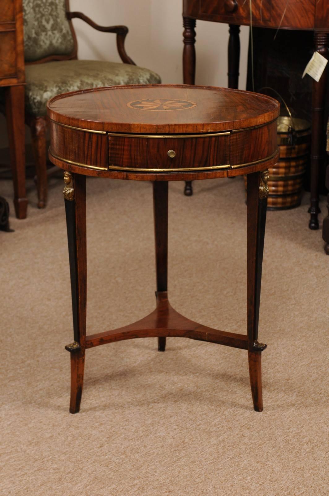 The early 19th century Italian figured walnut gueridon/round side table with parquetry center medallion, brass banding around apron and ebonized legs with mounts and stretcher. 

 