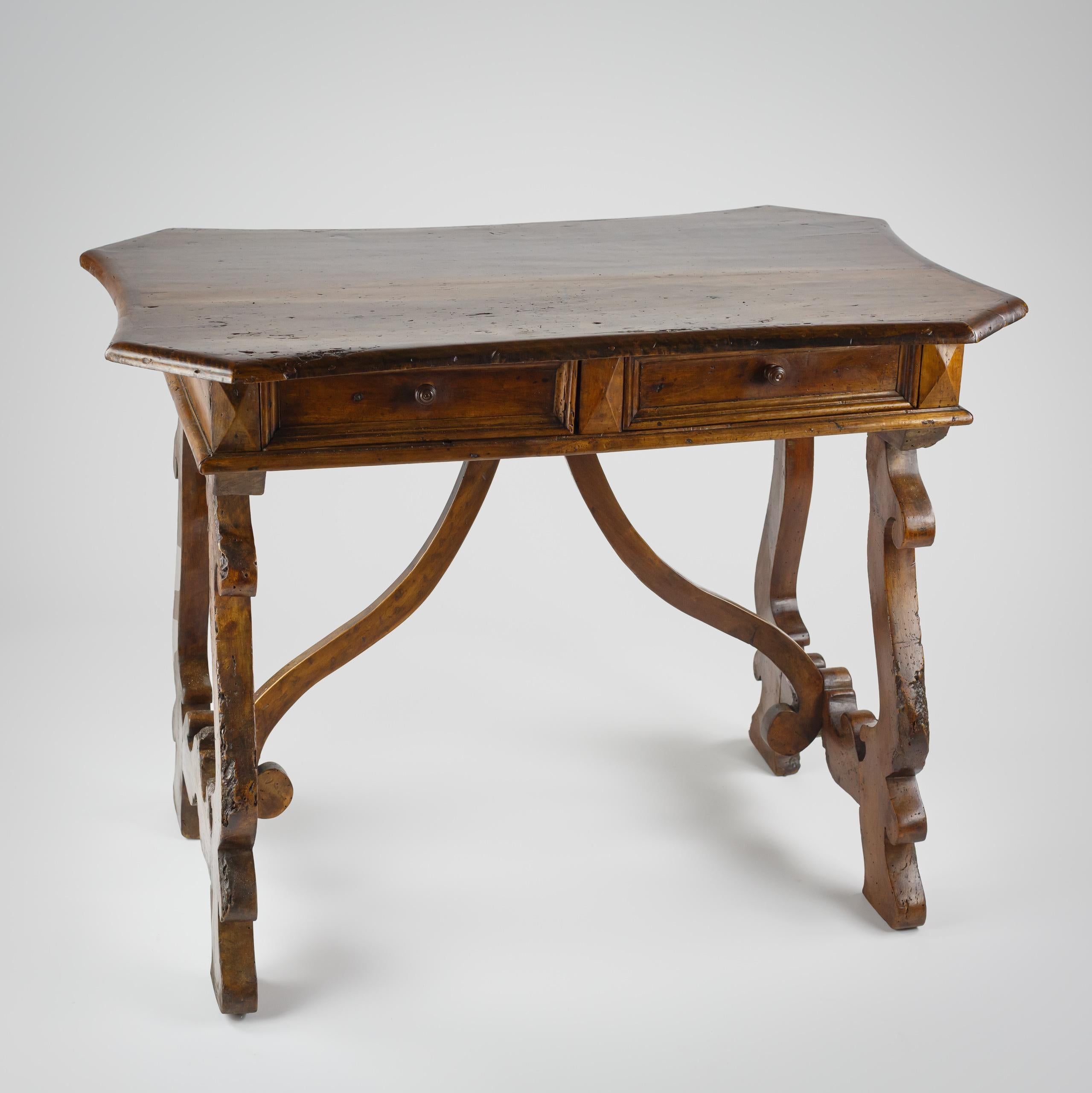 Insolito tavolino o scrivania italiano con due cassetti. Insolito piano in noce a serpentina associata con angoli inclinati e una patina eccellente. Noce Circa 1820. Come previsto, usura e patinatura - buon colore. Alcuni danni storici da verme